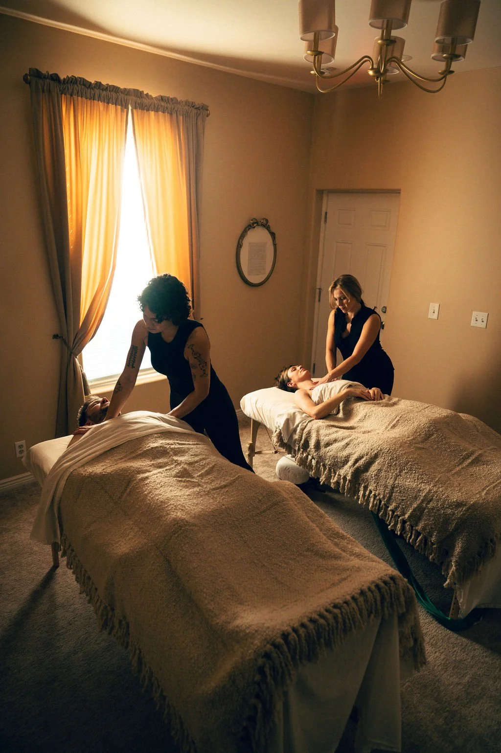 Couples massage in Salt Lake City at Kalm Sanctuary, featuring two guests receiving synchronized full-body massage in a private, calming spa room