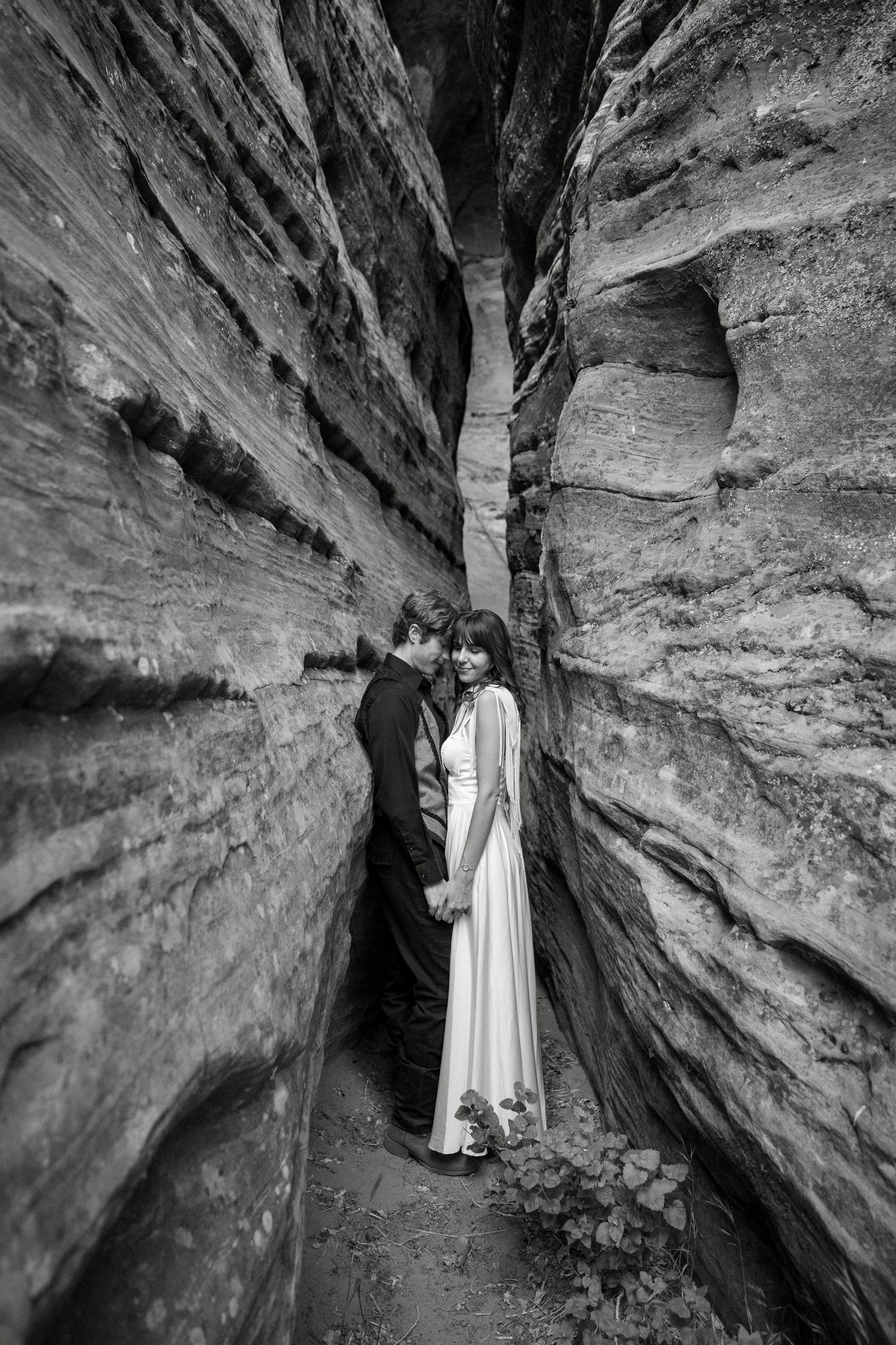A couple holds hands in a slot canyon in Zion National Park, Utah.