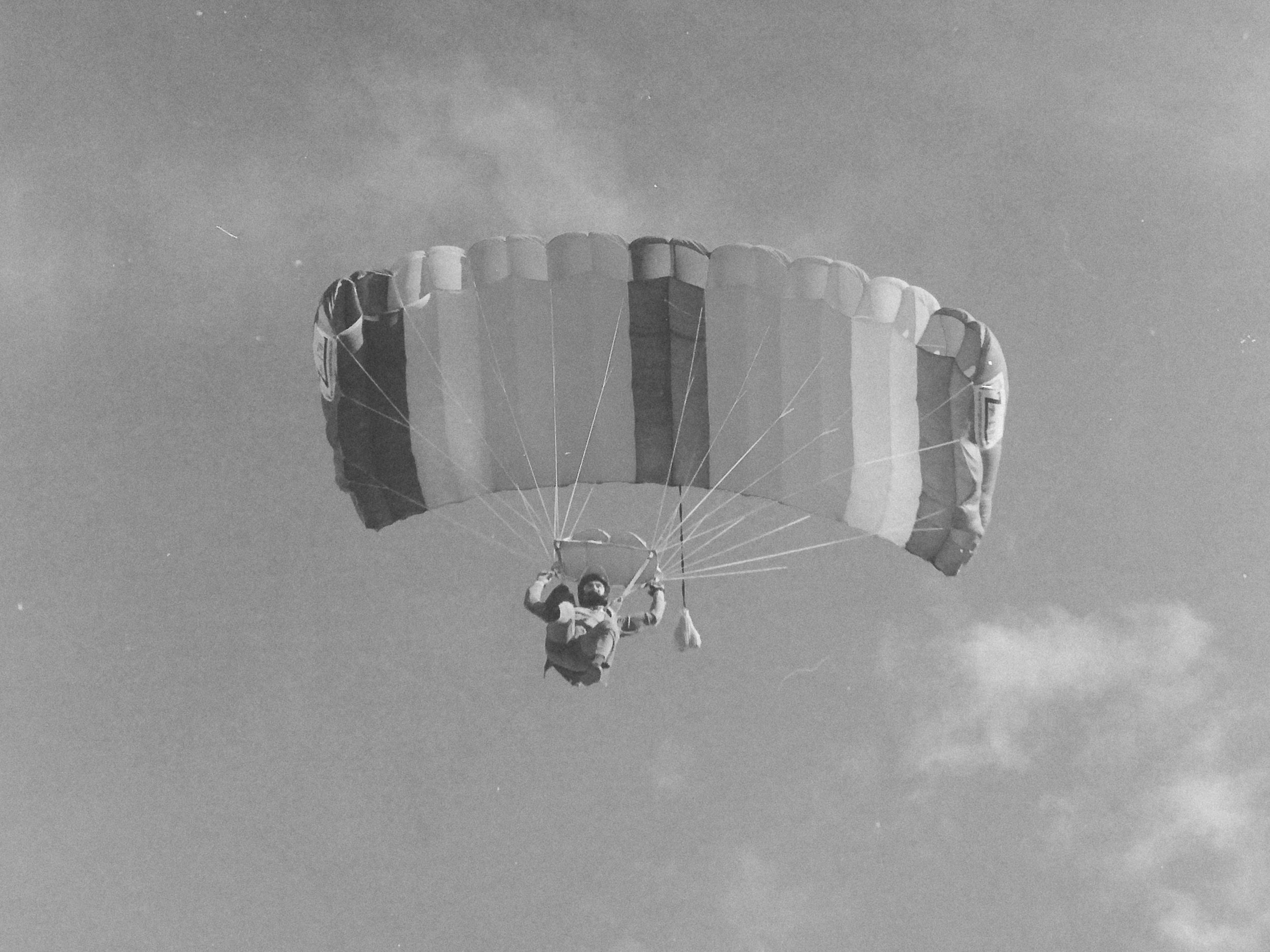 Black and white 35mm film photo of a sport skydiver descending under canopy at Skydive Skydown.