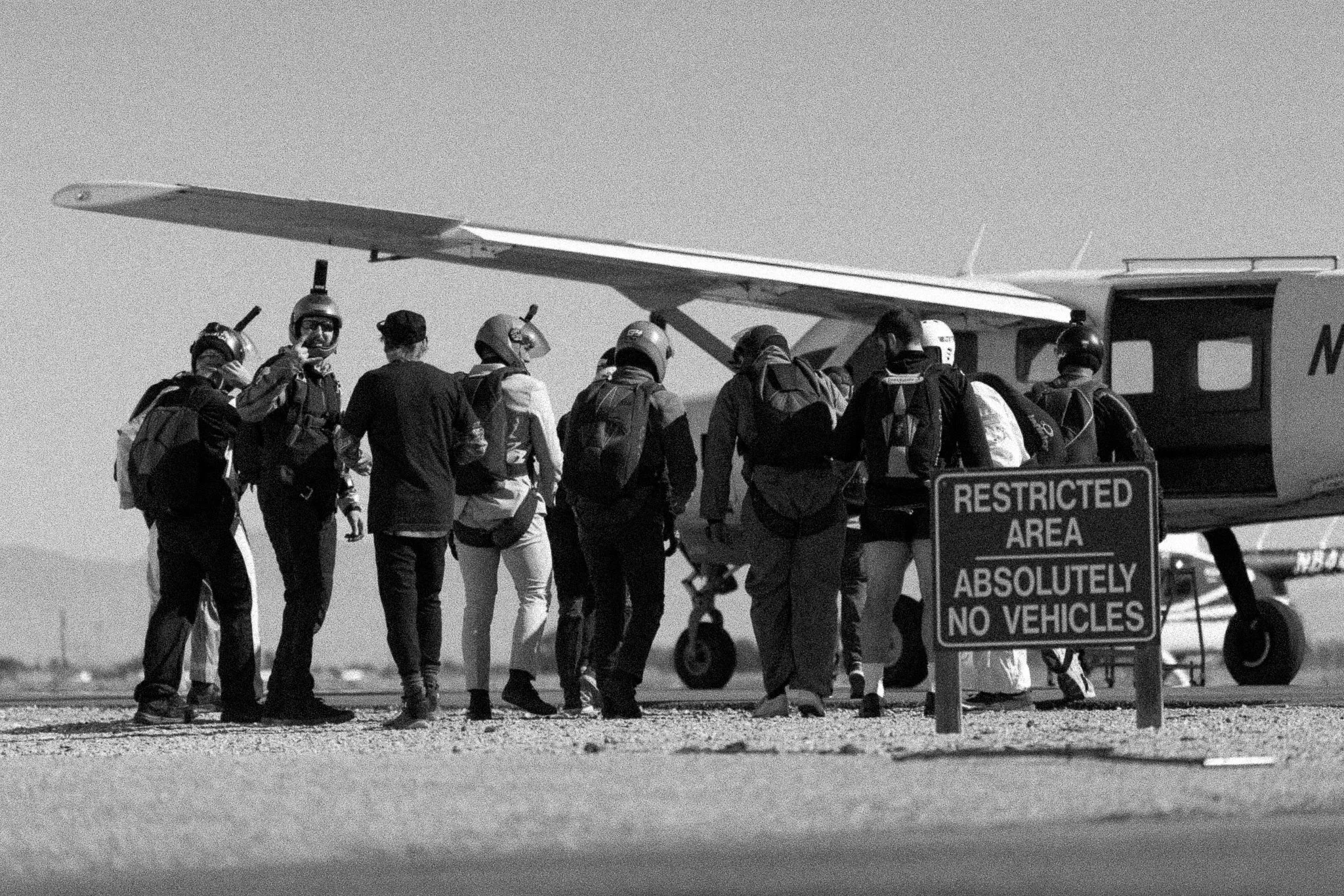 Black and white photo of licensed skydivers loading into the Caravan aircraft at Skydive Skydown.