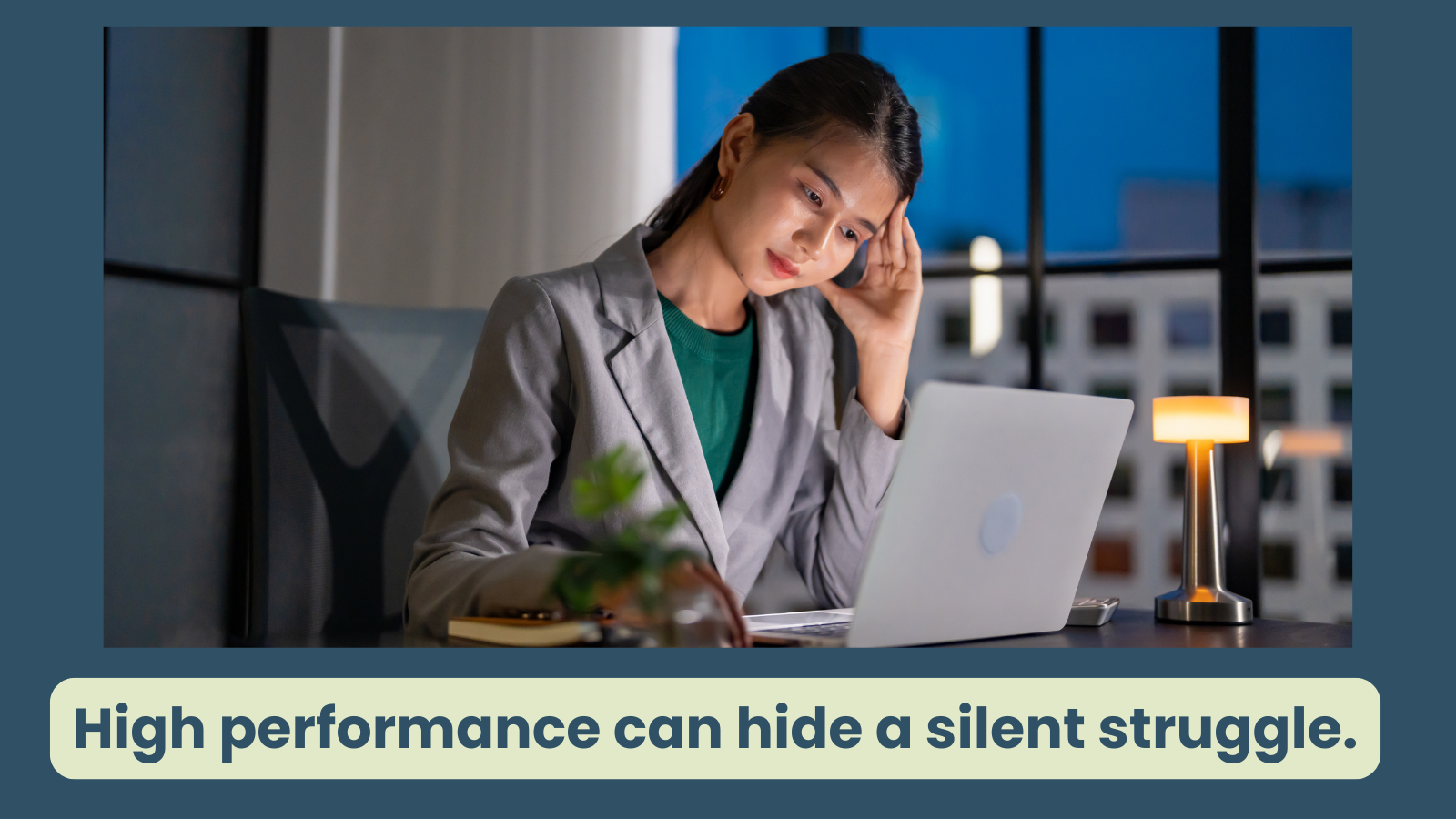 a woman works late at night, she looks at her laptop, her hand touches her head, indicating her brain is fatigued