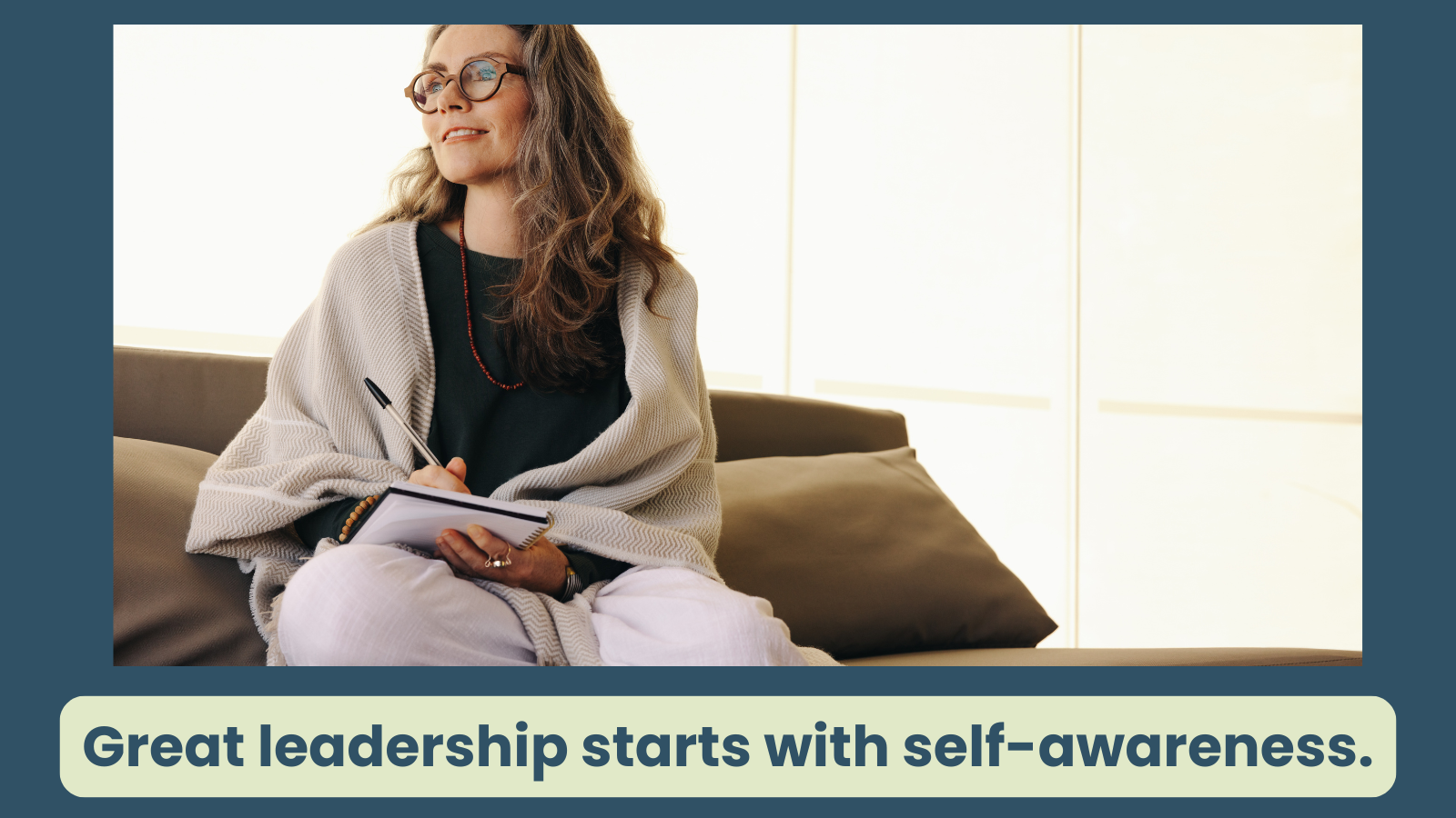 Woman smiling with a note pad as she practices self reflection and journaling