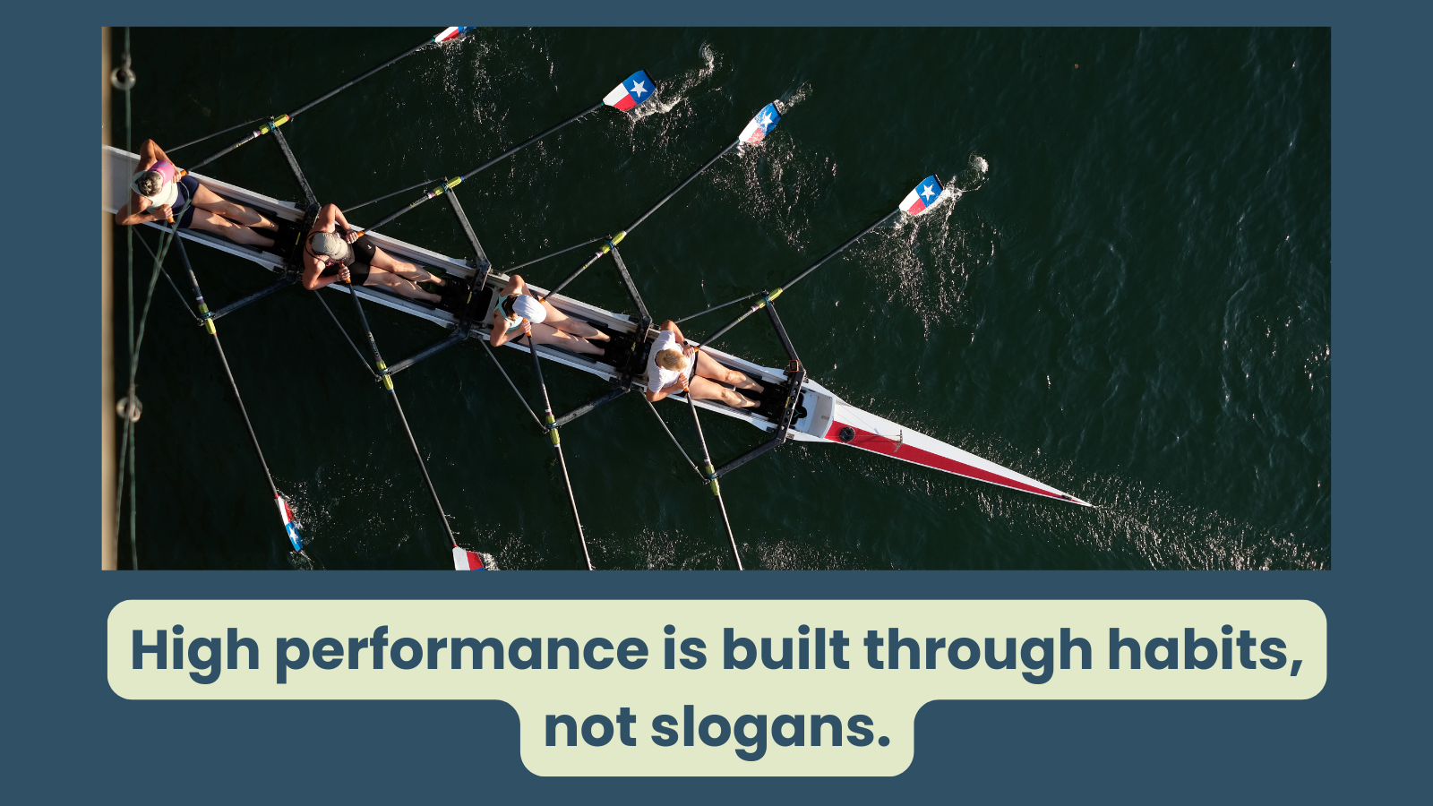 A team of women are in a rowing boat and workig together