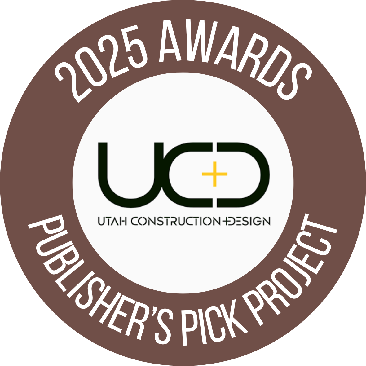 A circular badge with a brown border and white inner circle, displaying the text "2025 Awards" at the top and "Publisher's Pick Project" at the bottom. The center features a logo with the text "UTAH CONSTRUCTION + DESIGN" and a stylized "U + D" in black, with a yellow plus sign in the middle.