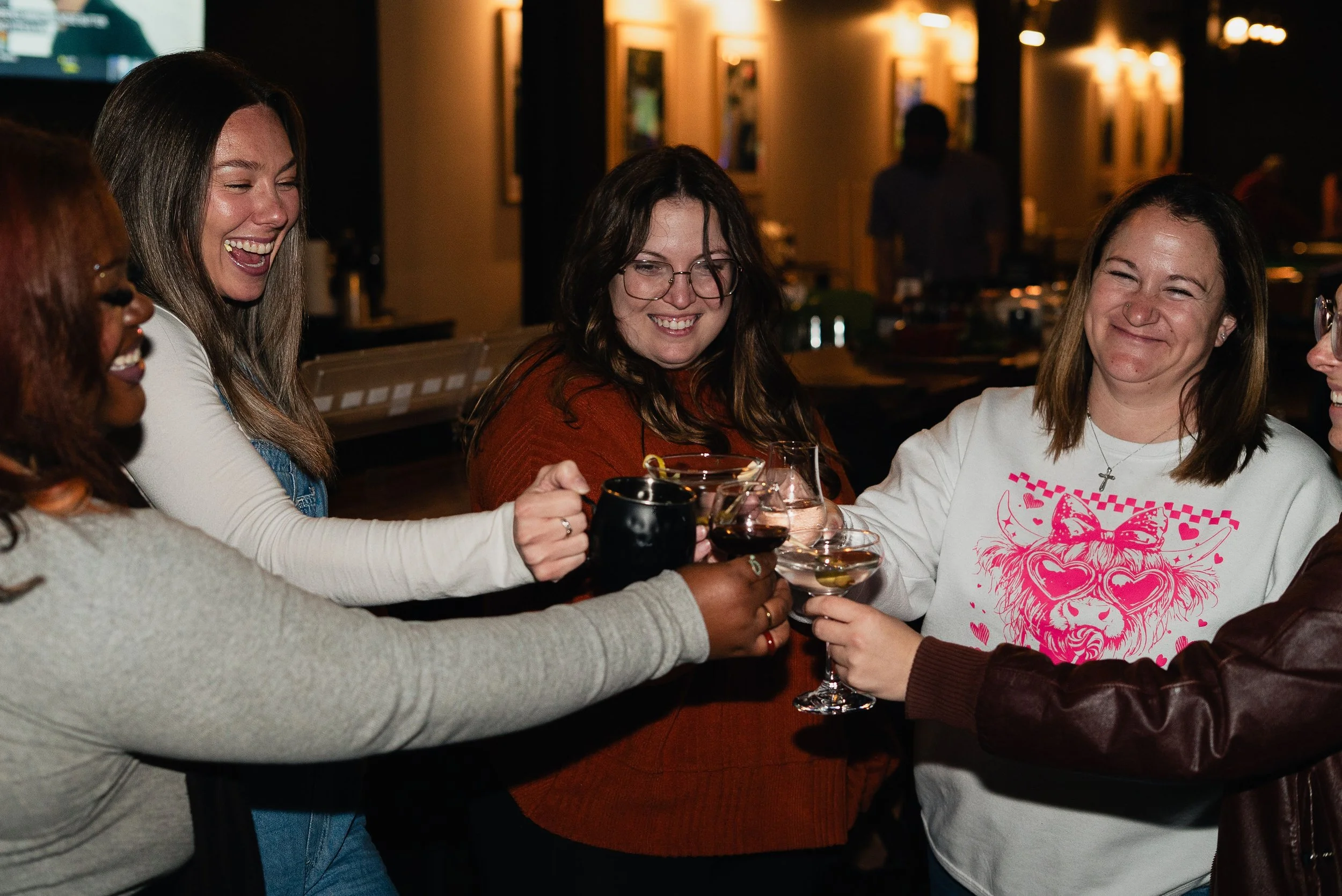 Group of five women raising glasses in a toast at a social gathering at the Villa Golf Lounge.