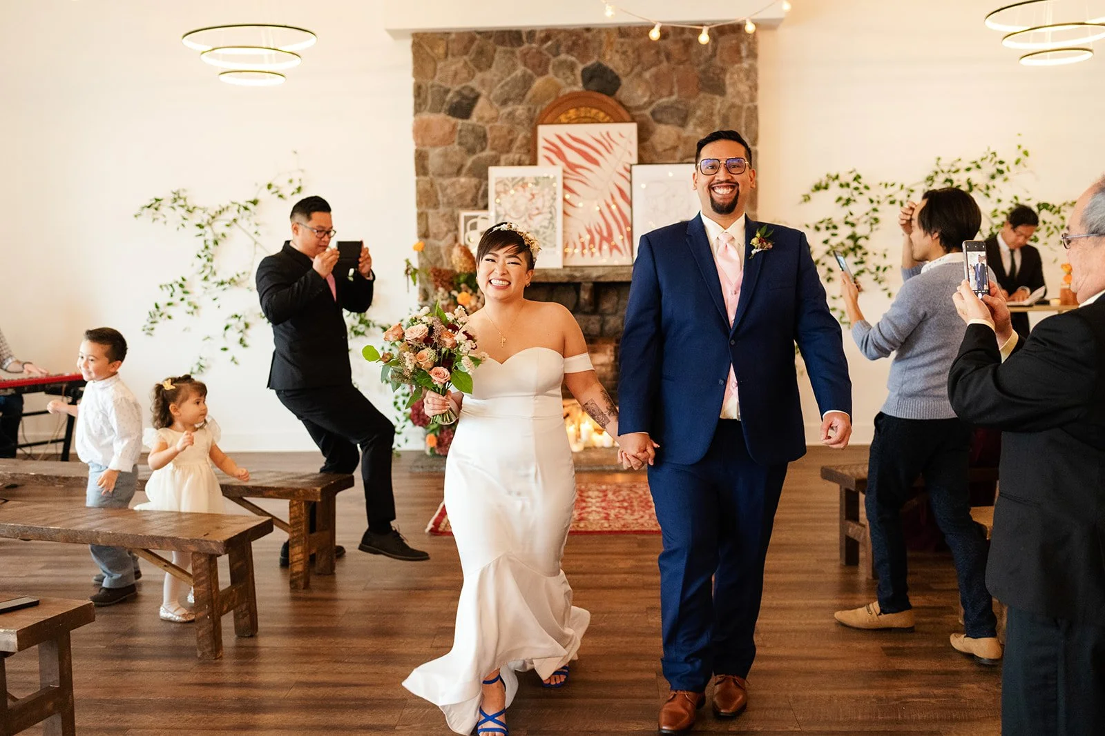a bride and groom walking down the aisle happily at their recessional, guests are applauding