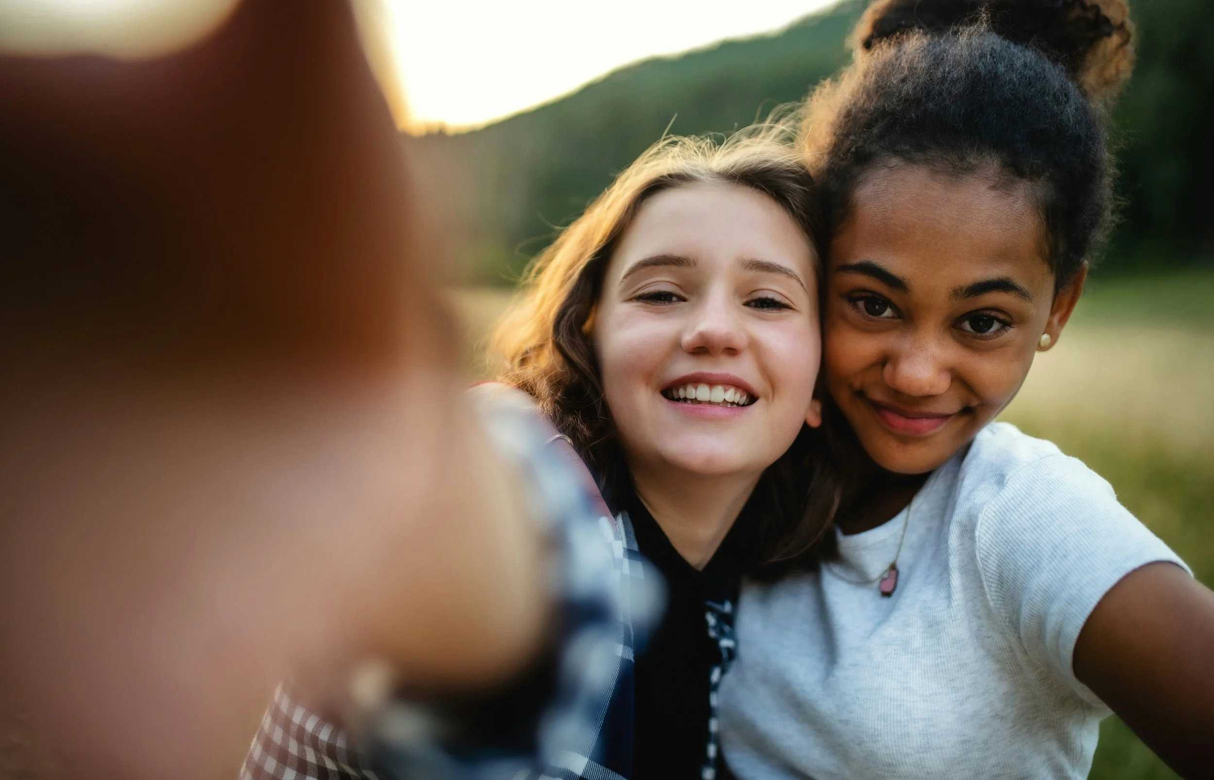 Selfie of two teen girls smiling.