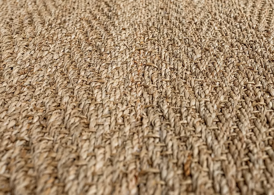 Close-up of a woven, Herringbone Seagrass, textured rug made of natural fibres.