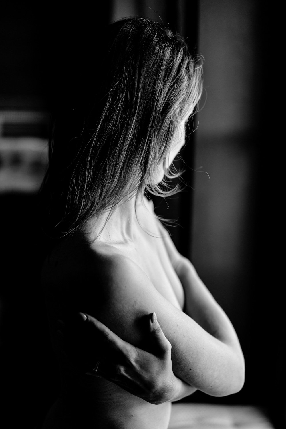 Femme embrassant sa poitrine, photographie en noir et blanc.