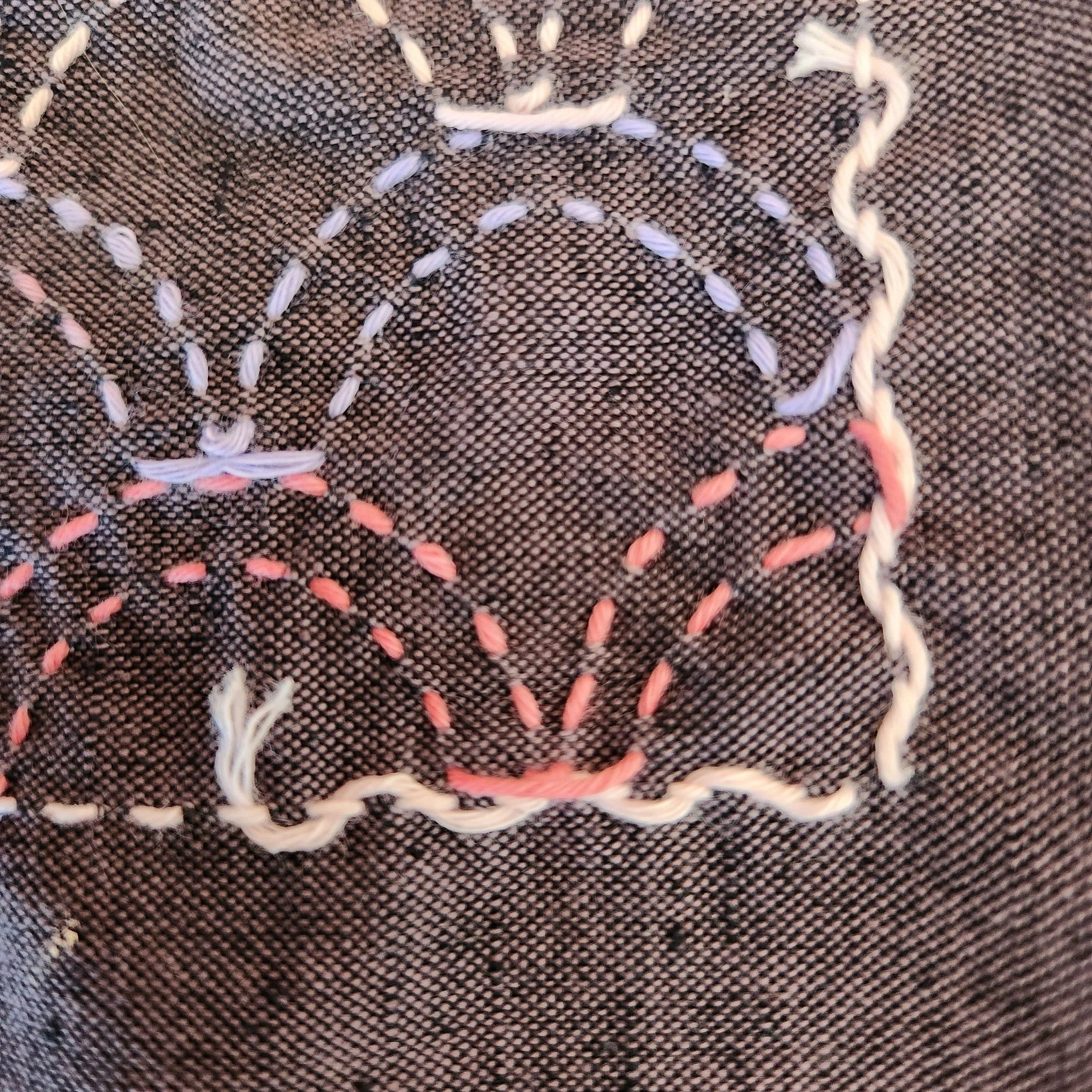 Back of sashiko coaster showing thread tail woven in to start stitching