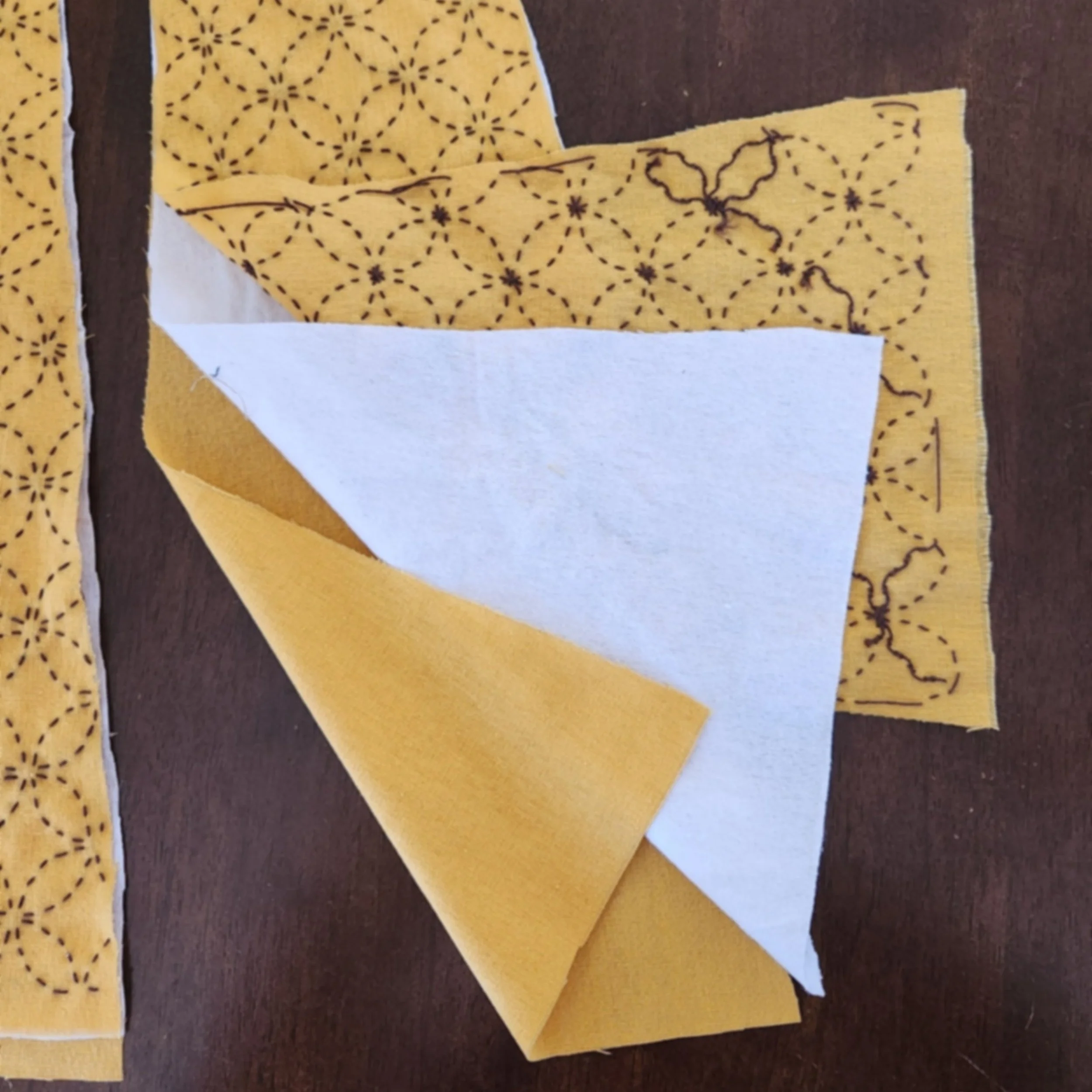 Stacked fabric layers showing sashiko-stitched linen, white flannelette, and plain linen backing.