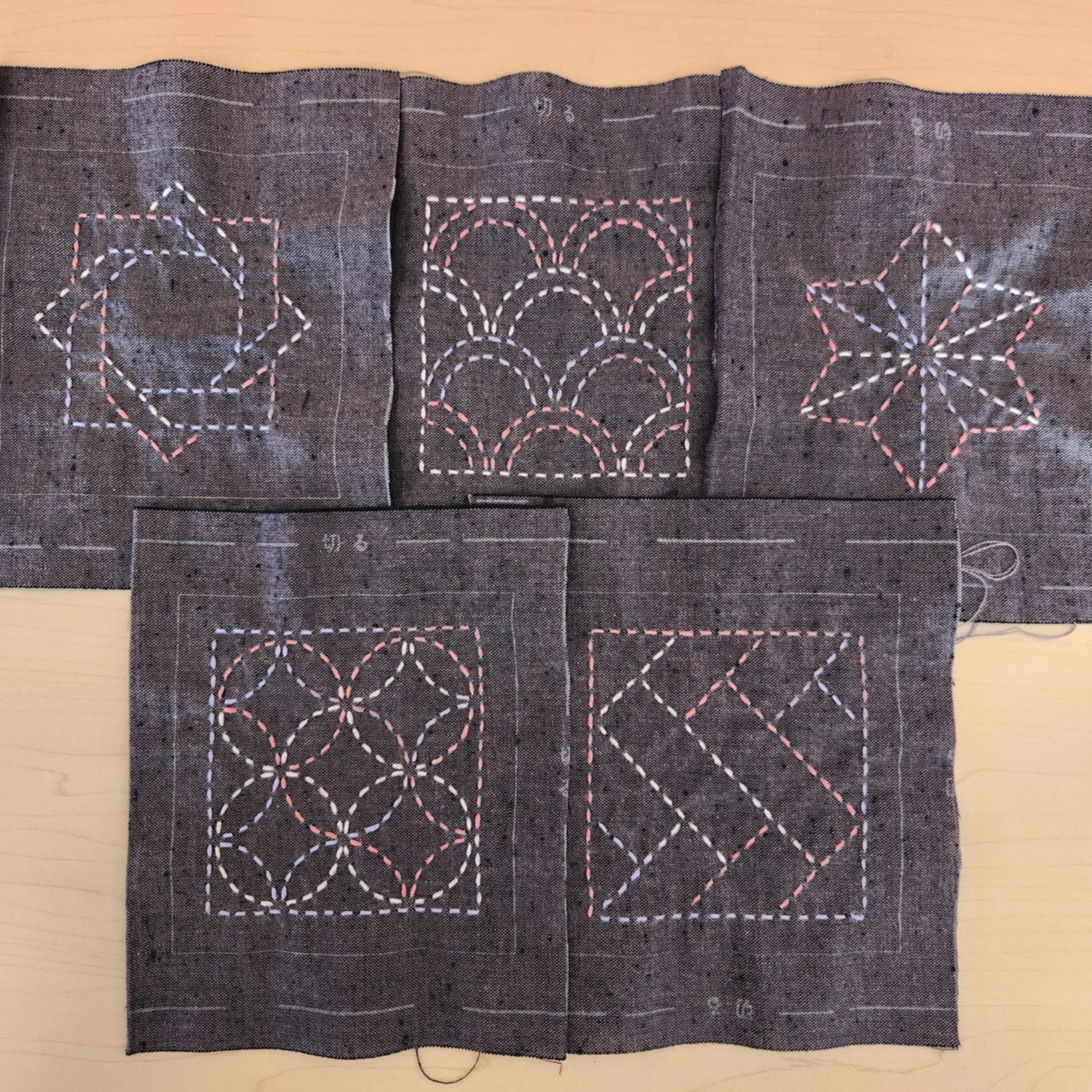Close-up of five different sashiko patterns stitched from the TC-4 Purple coaster collection.