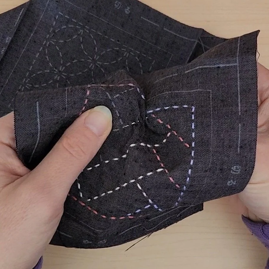 Needle stitching along pre-printed sashiko pattern lines.