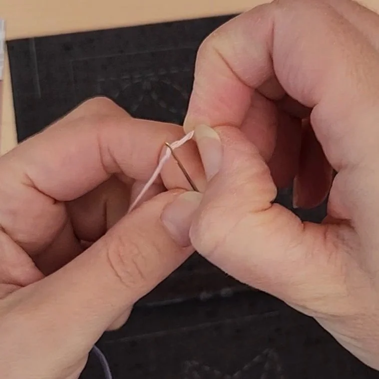 Sashiko needle being threaded.