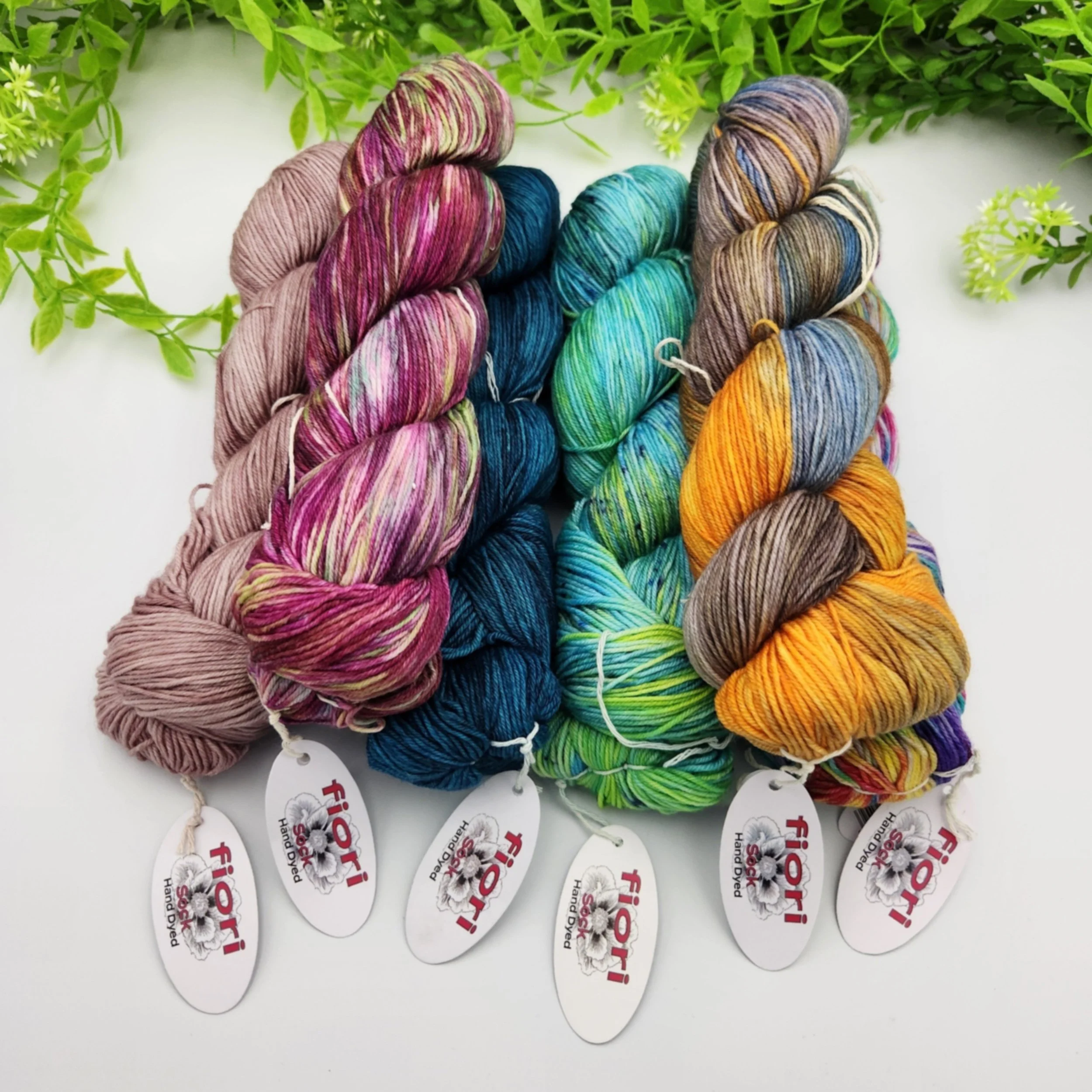 Fiori hand dyed sock yarn in colours Tapestry, Mermaid Waters, Abalone, Turkist Blue, and Waratah Winter Sunrise grouped together.