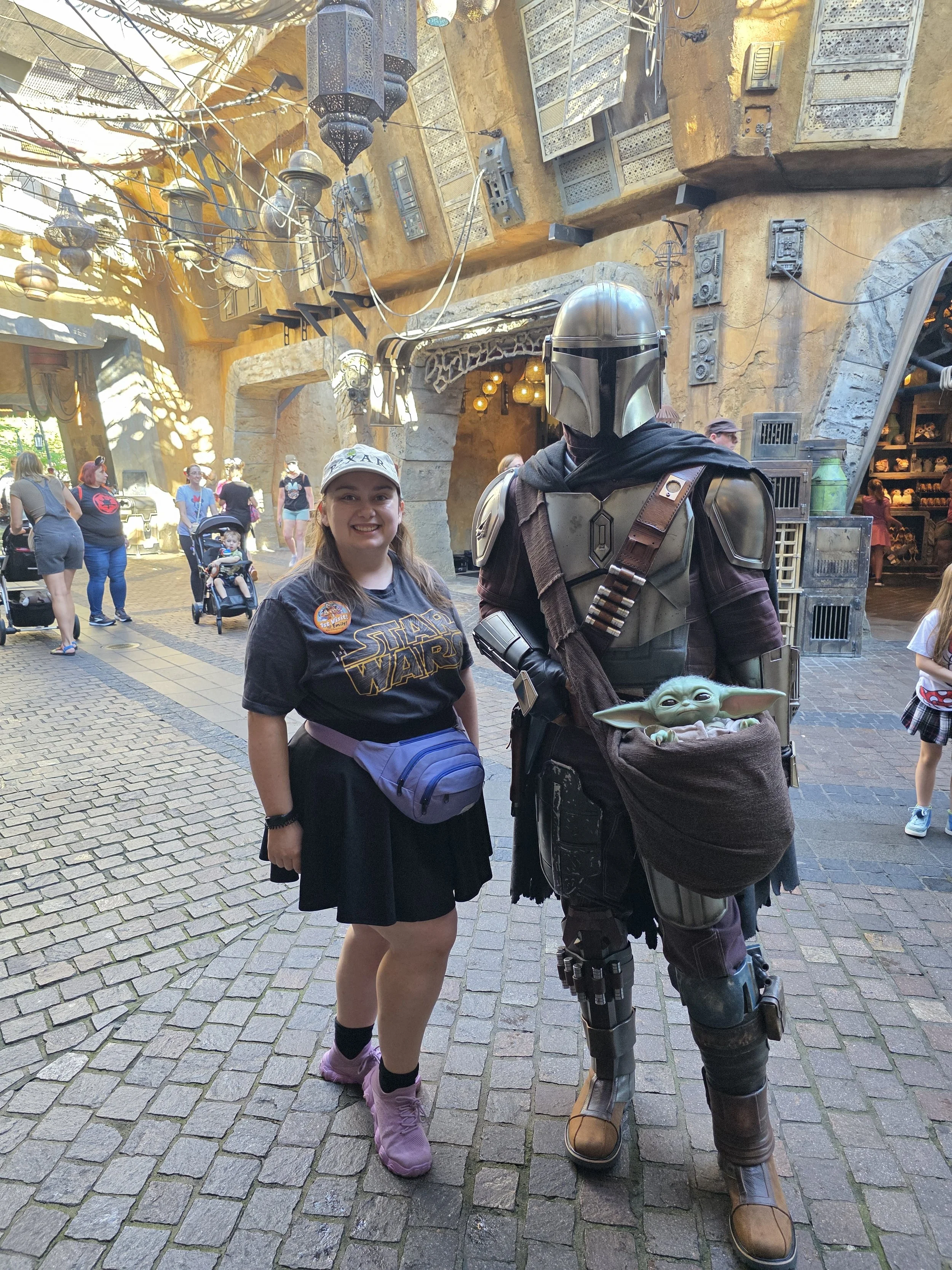 Emily posing for a photo with the Mandalorian and Grogu