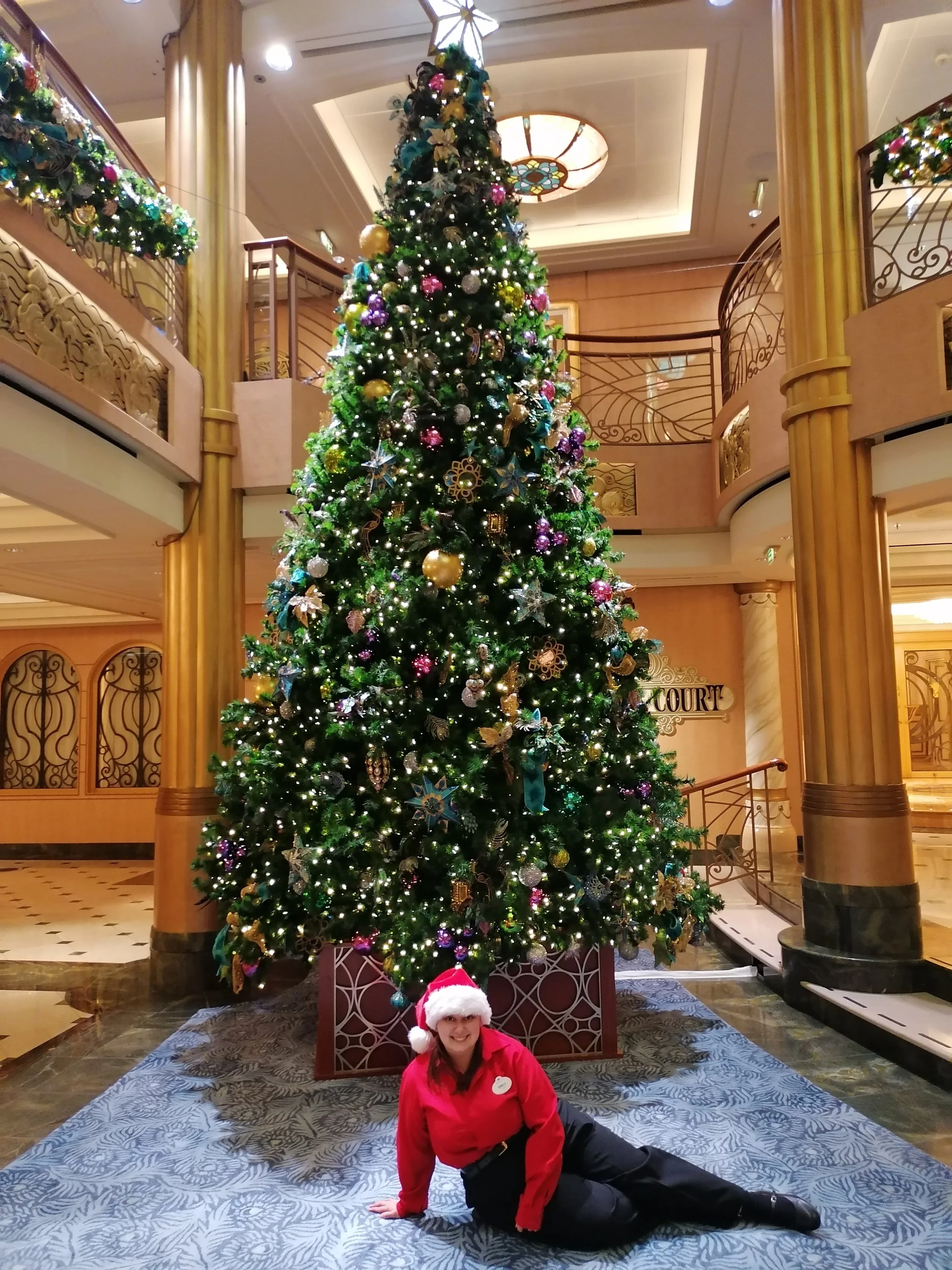 Emily Stangroom posing in front of the Holiday tree on the Disney Fantasy