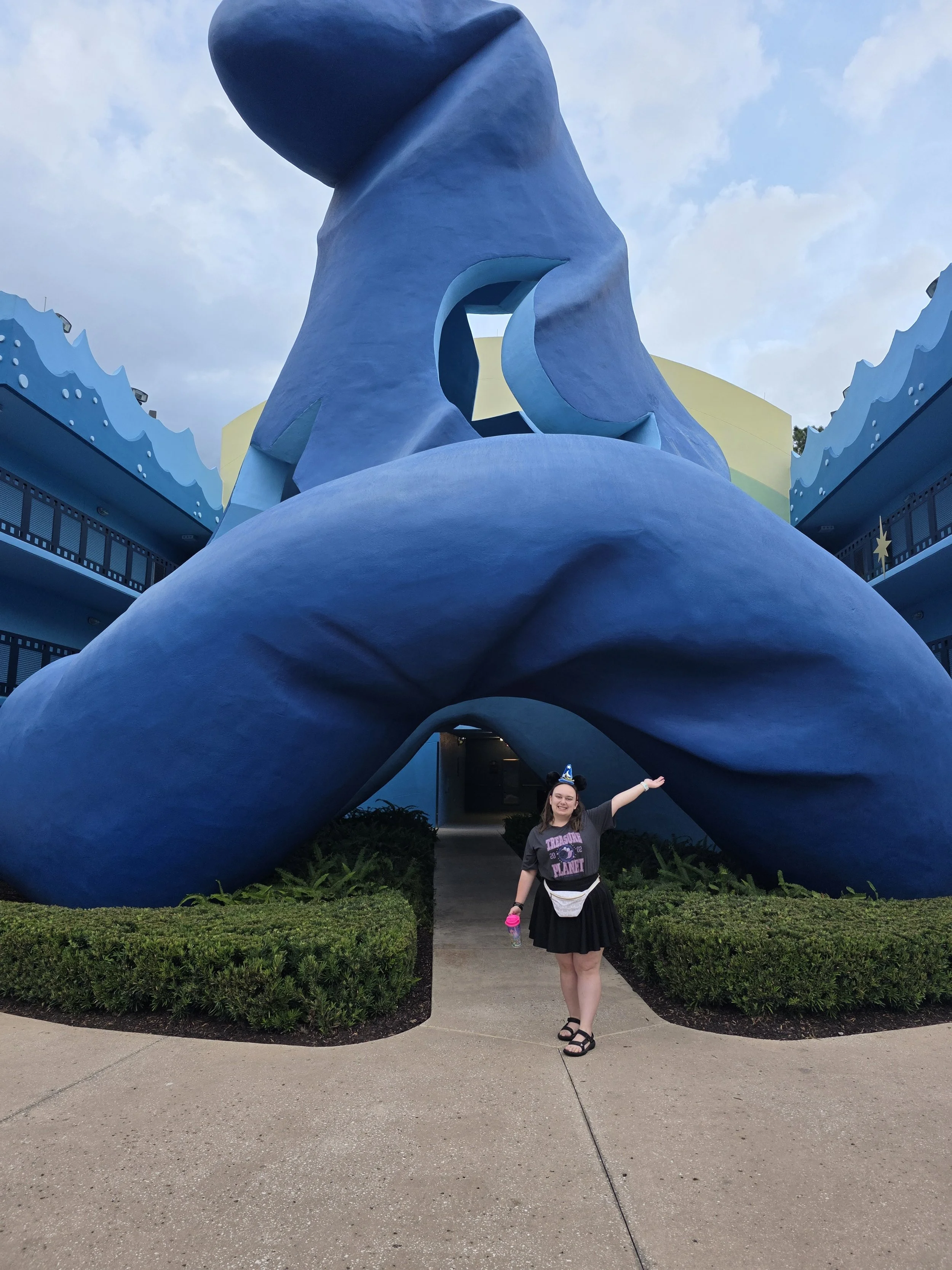 Emily standing in front of Mickey's sorcerer hat at All Star Movies