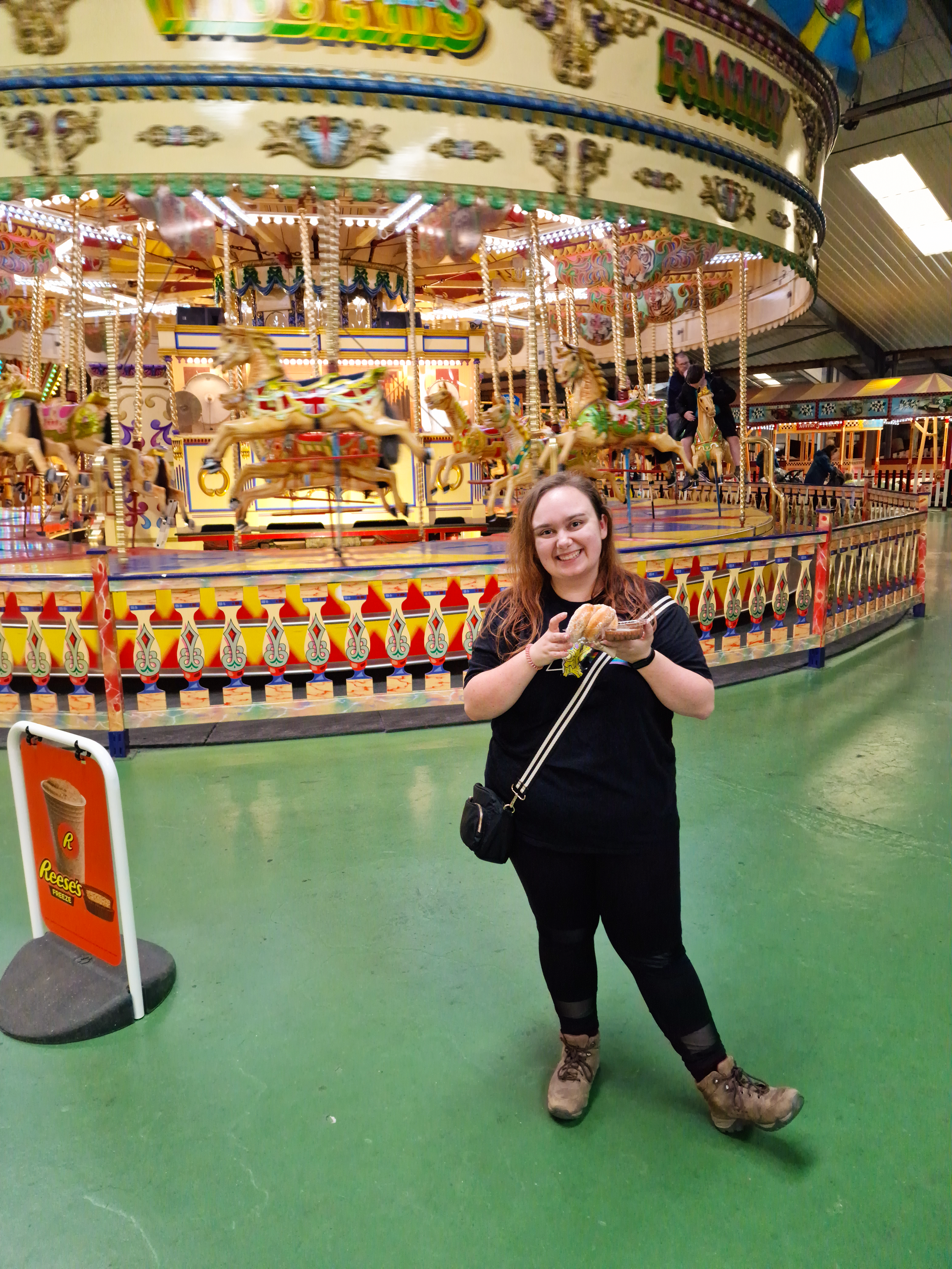 Plus size woman standing in front of the carousel at Folly Farm