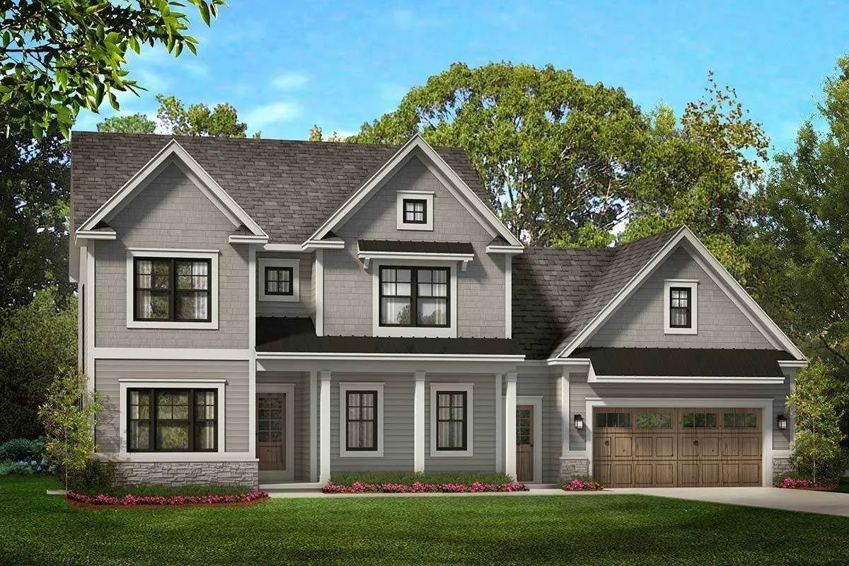 A two-story modern gray house with black window frames and a brown garage door, surrounded by green trees and a lawn with flower beds.