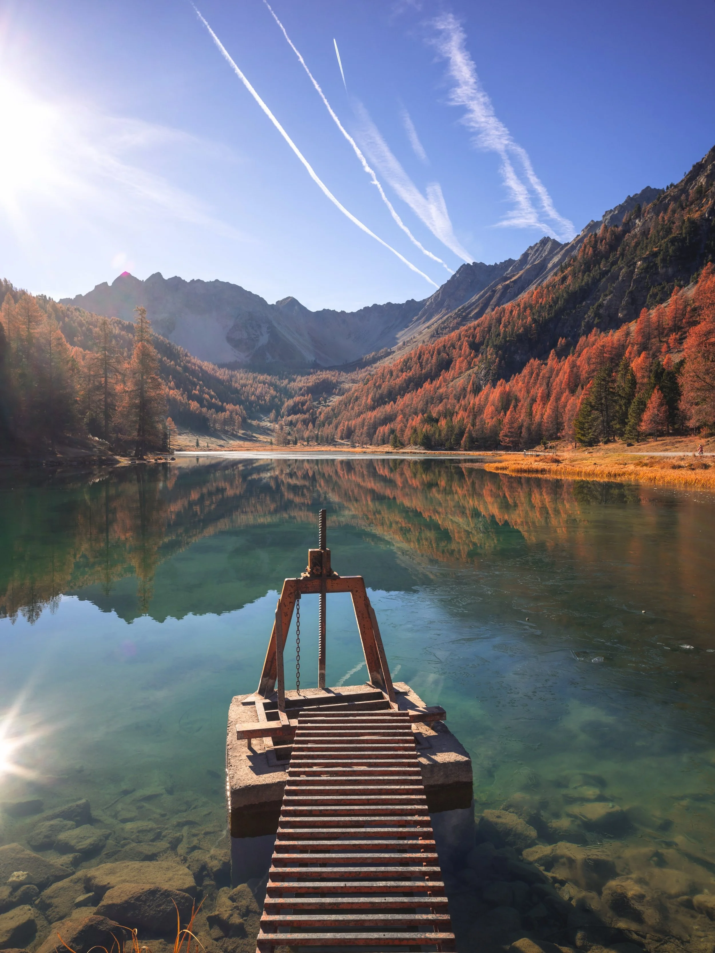 Before the snow, there&rsquo;s this.
The larches catch fire, the air turns crisp, and the lake goes perfectly still, like the mountain is holding its breath for winter.
Autumn in the Hautes-Alpes is the best-kept secret of the year. Come and see it f