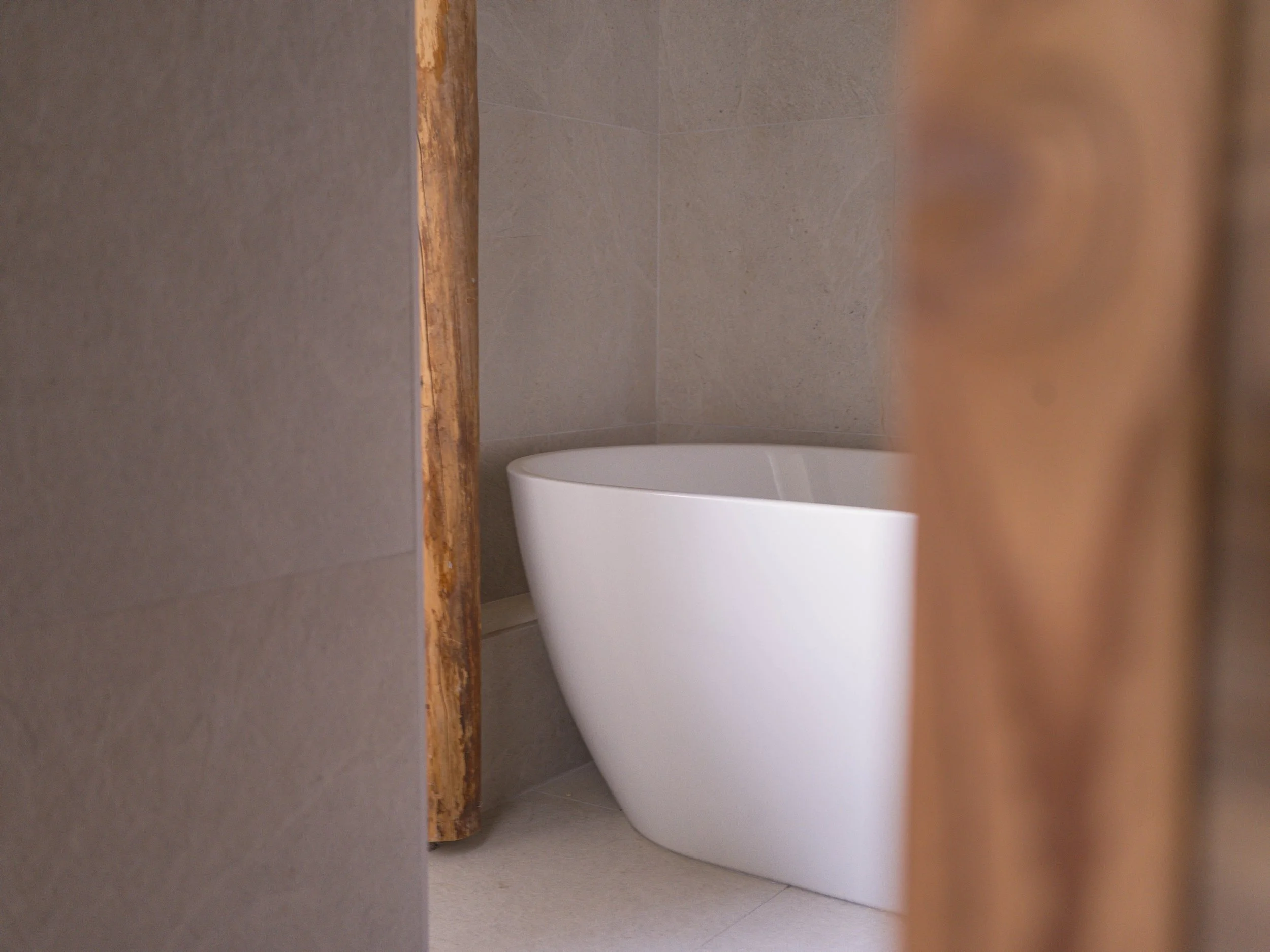 Gros plan sur des toilettes modernes dans une salle de bains aux murs carrelés de couleur beige.