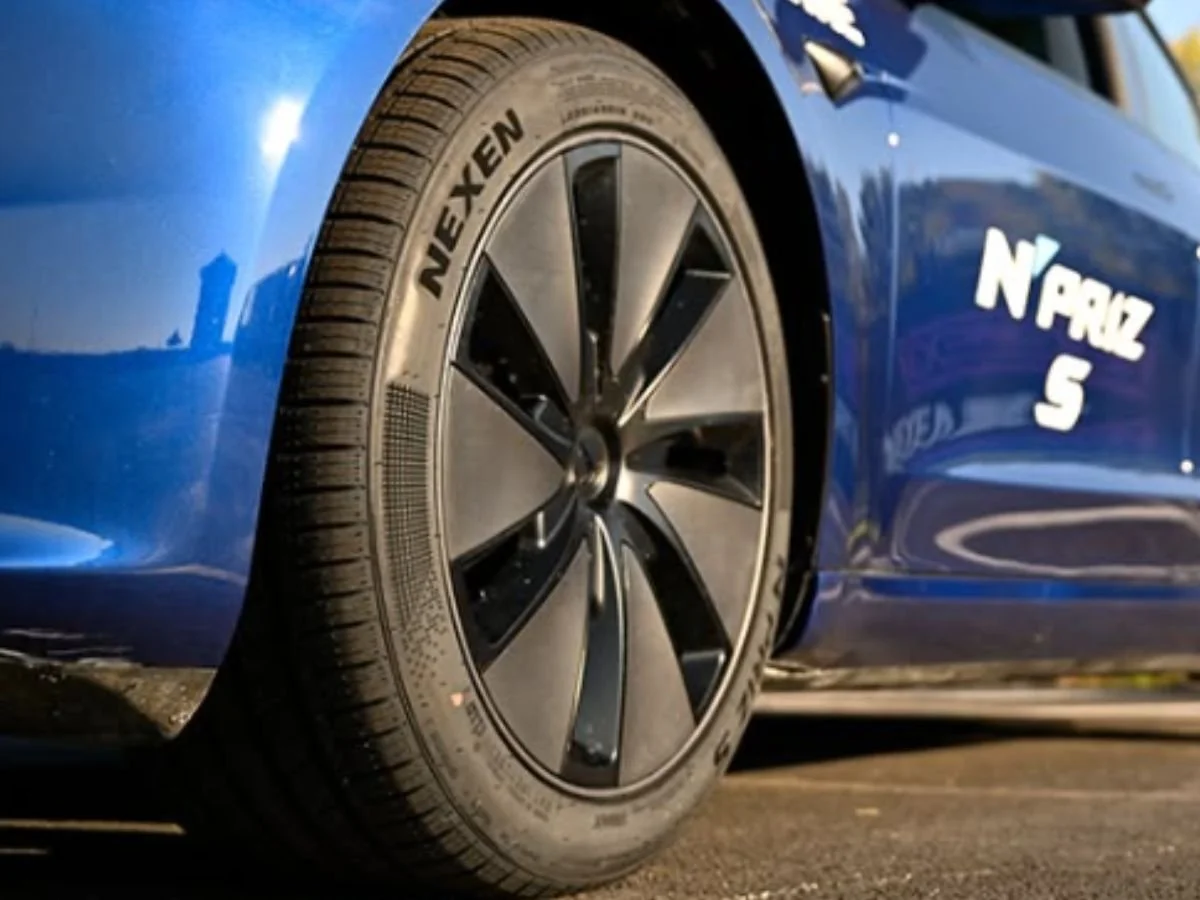 Nexen N'Priz S EV-compatible tire on a blue Tesla with a black aerodynamic wheel cover and white branding.