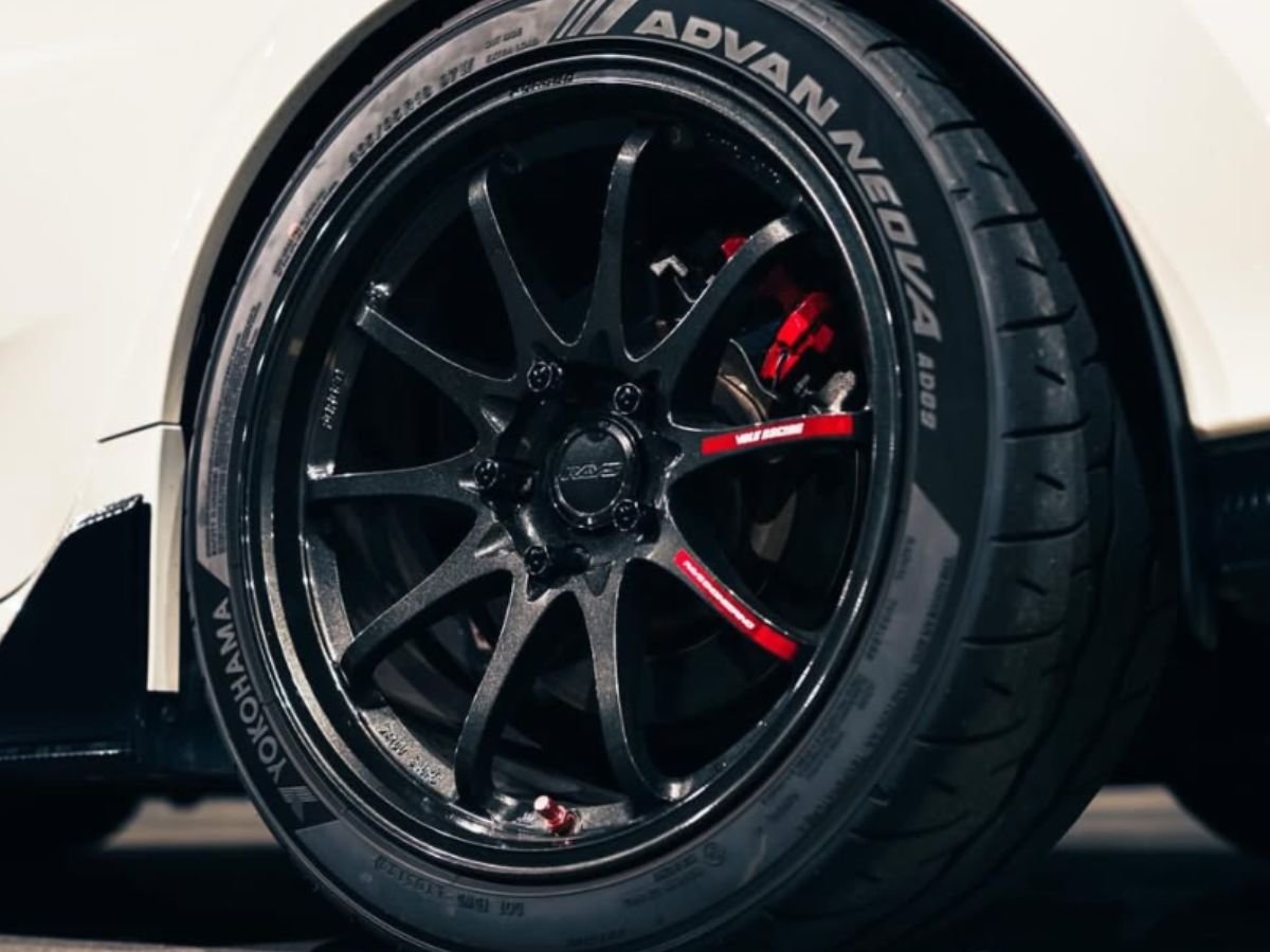 Yokohama ADVAN NEOVA AD09 extreme performance summer tire on a black multi-spoke wheel with red brake calipers.
