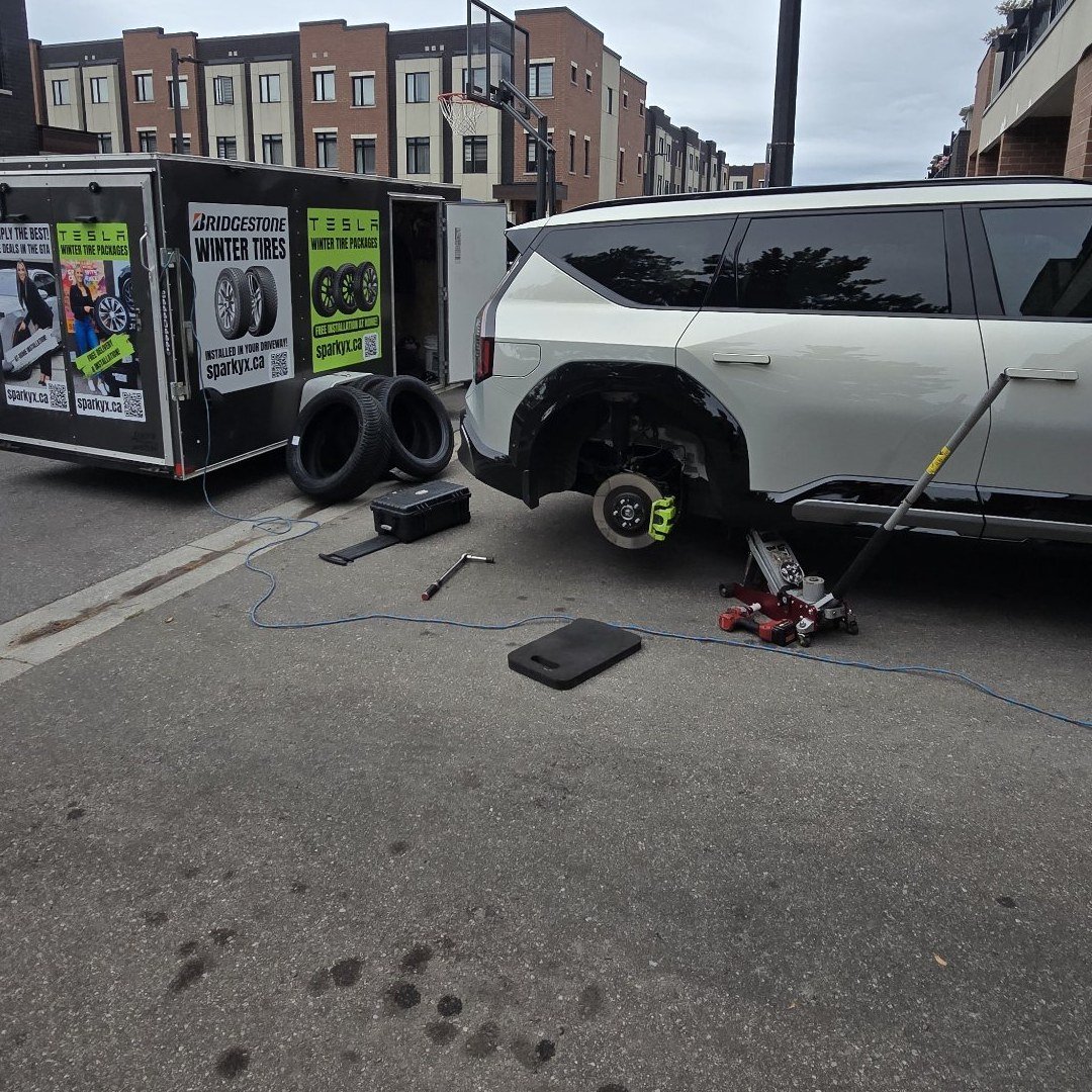 Sparky X mobile technician performing a driveway tire change in the GTA — service trailer, winter tires, and SUV on jack