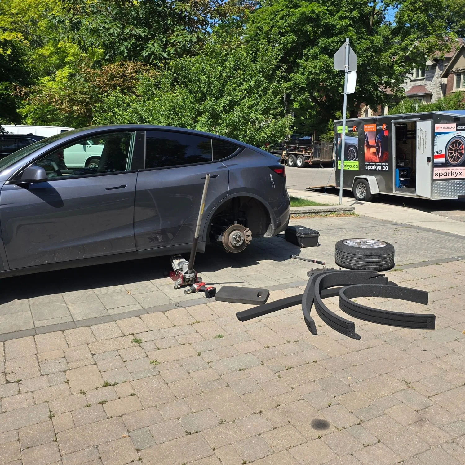Four strips of acoustic silencer foam just removed from a set of Tesla Model Y wheels, which were causing vibration at 100+ hm/hr - customer's driveway, Toronto.