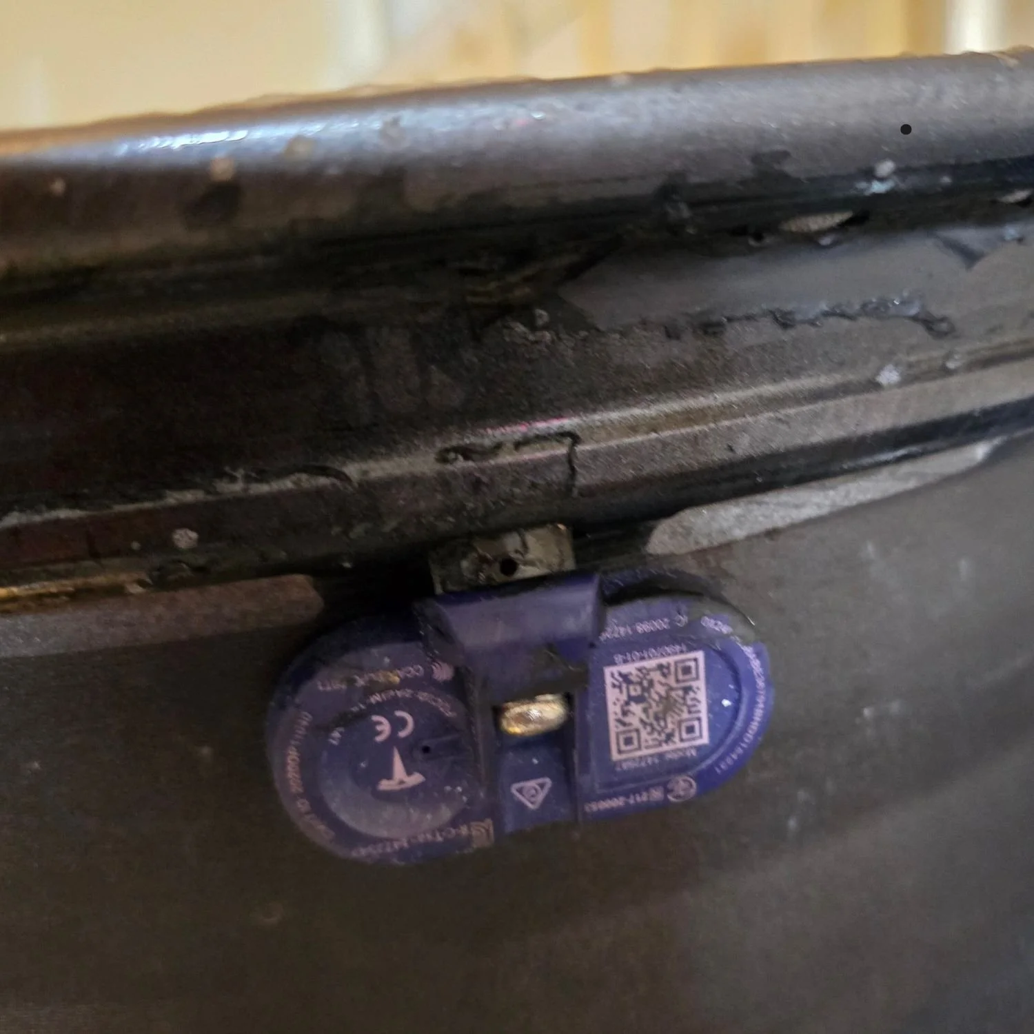 Defective TPMS sensor still mounted on a rim, before removal. Location - Toronto.