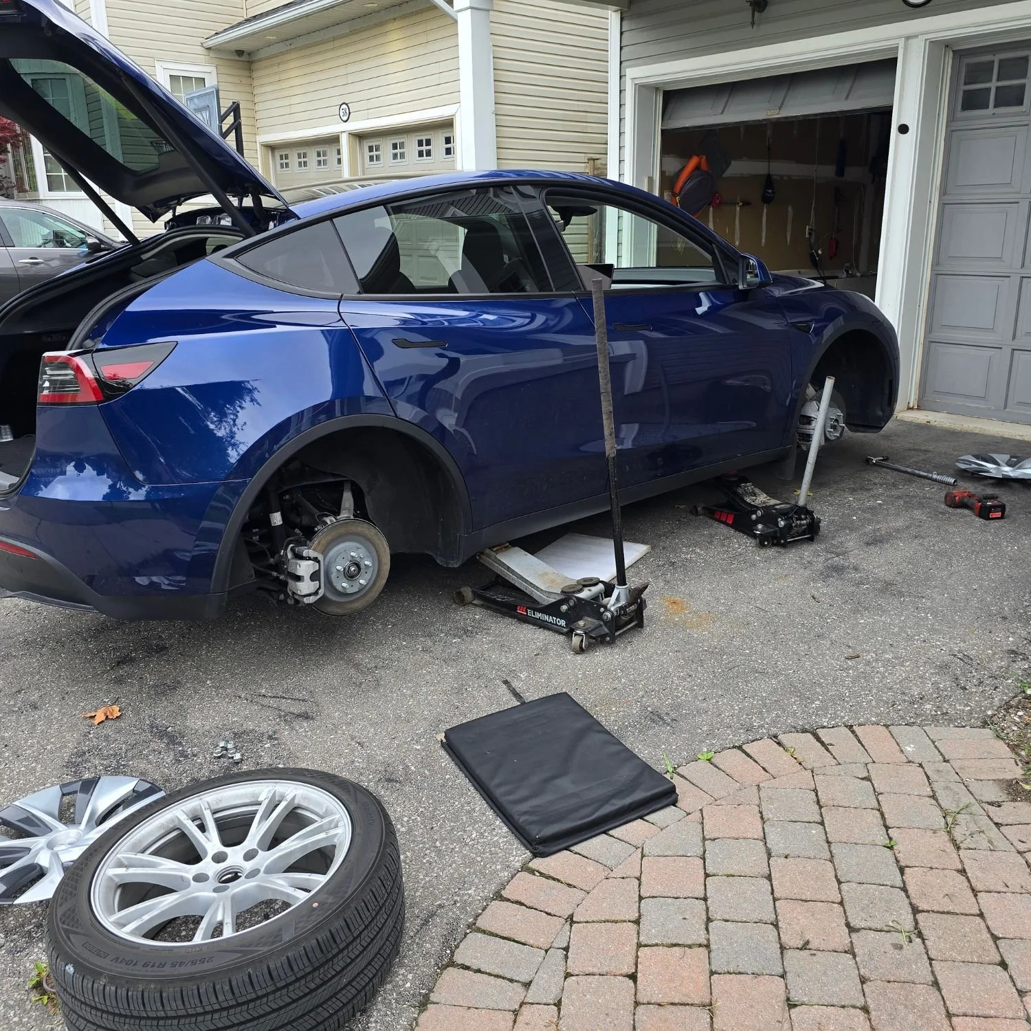 Mobile tire rotation service on customer's driveway in Ajax, Ontario, Tesla Model Y.