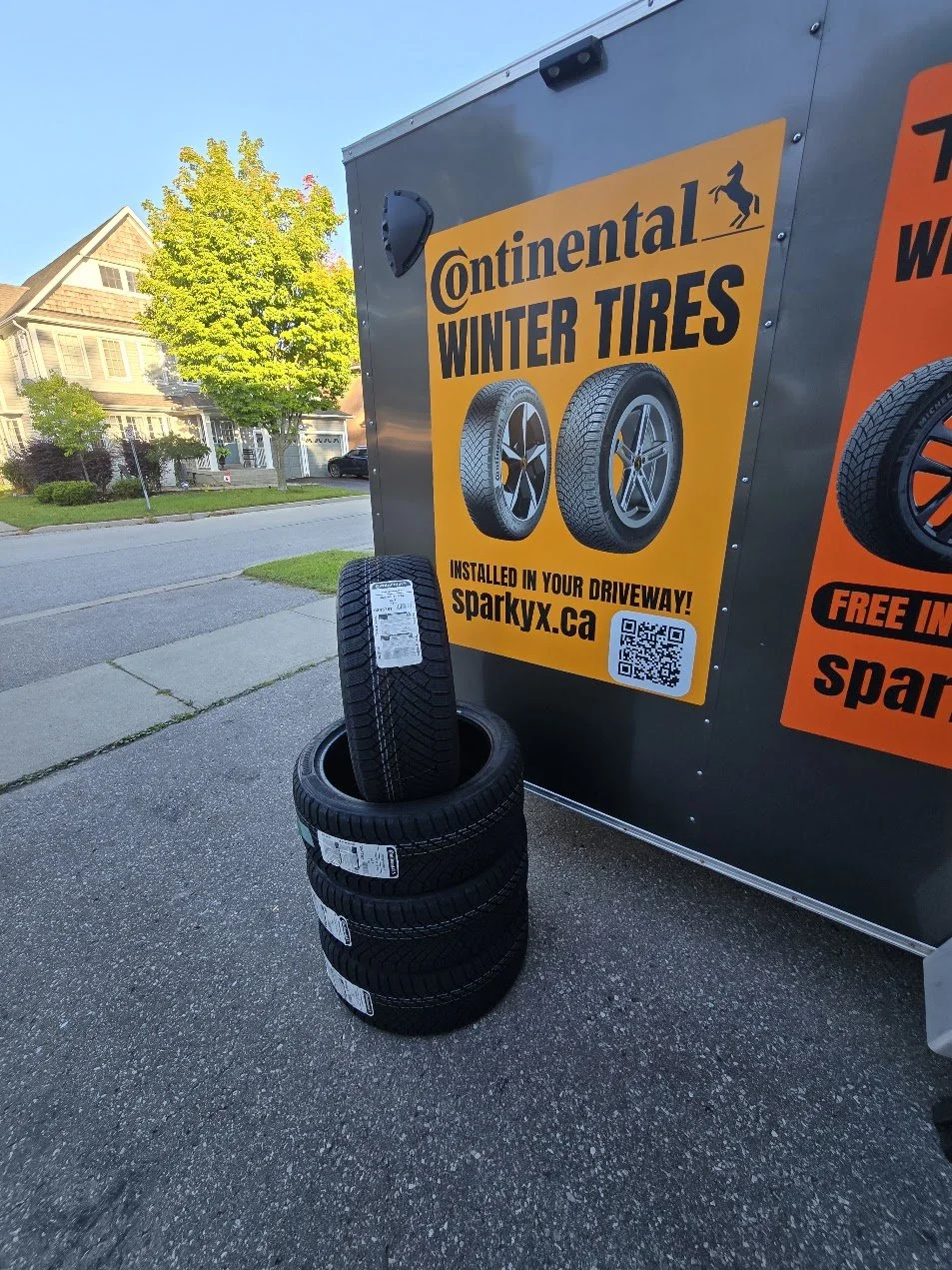 Brand new set of 4 quality tires near the Sparky X service trailer, ready for delivery and installation with warranty, rebates, the professional way.