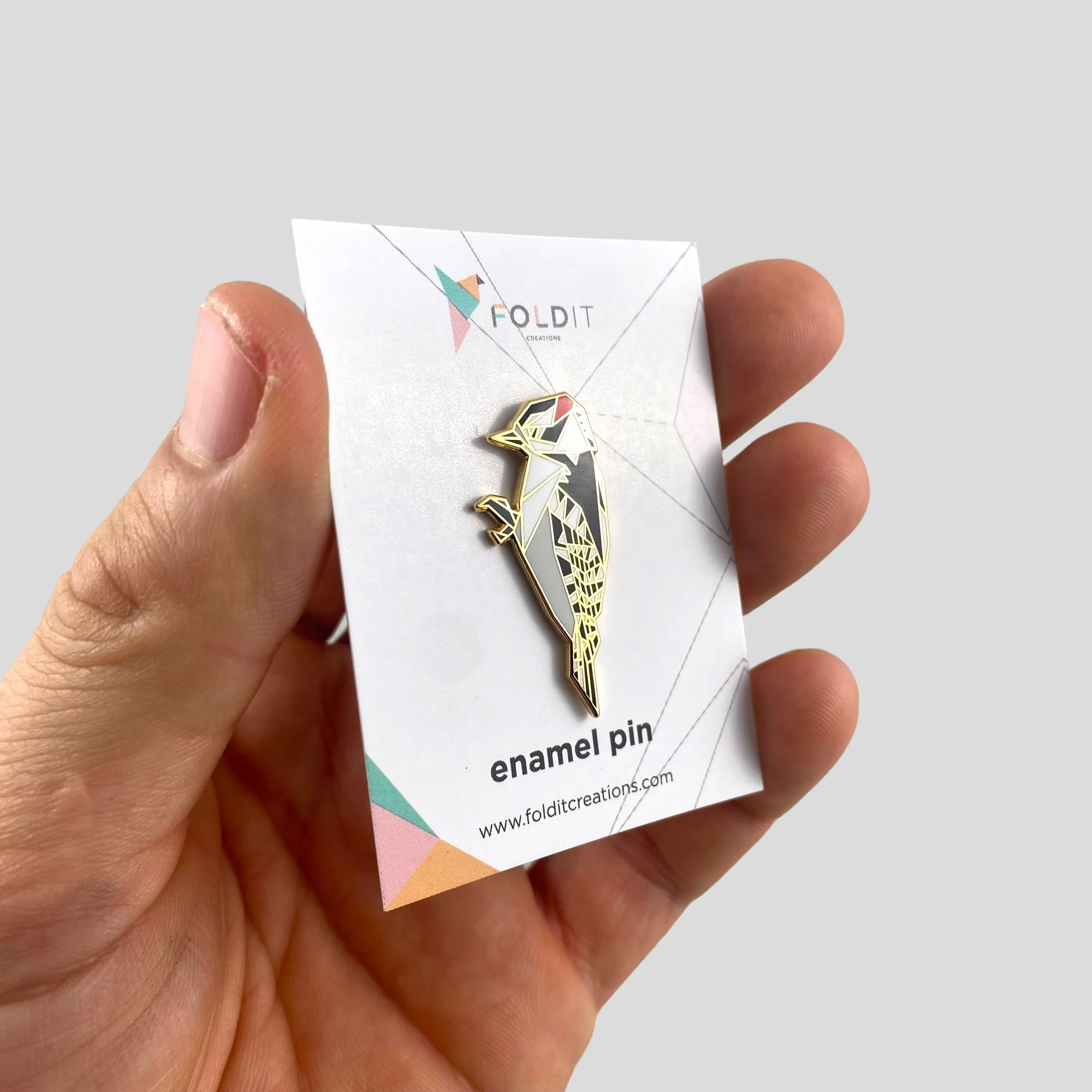 Origami downy woodpecker enamel pin – a unique bird themed gift for bird lovers and bird watchers. Hard enamel pin with secure double pin backing and original FoldIT Creations design