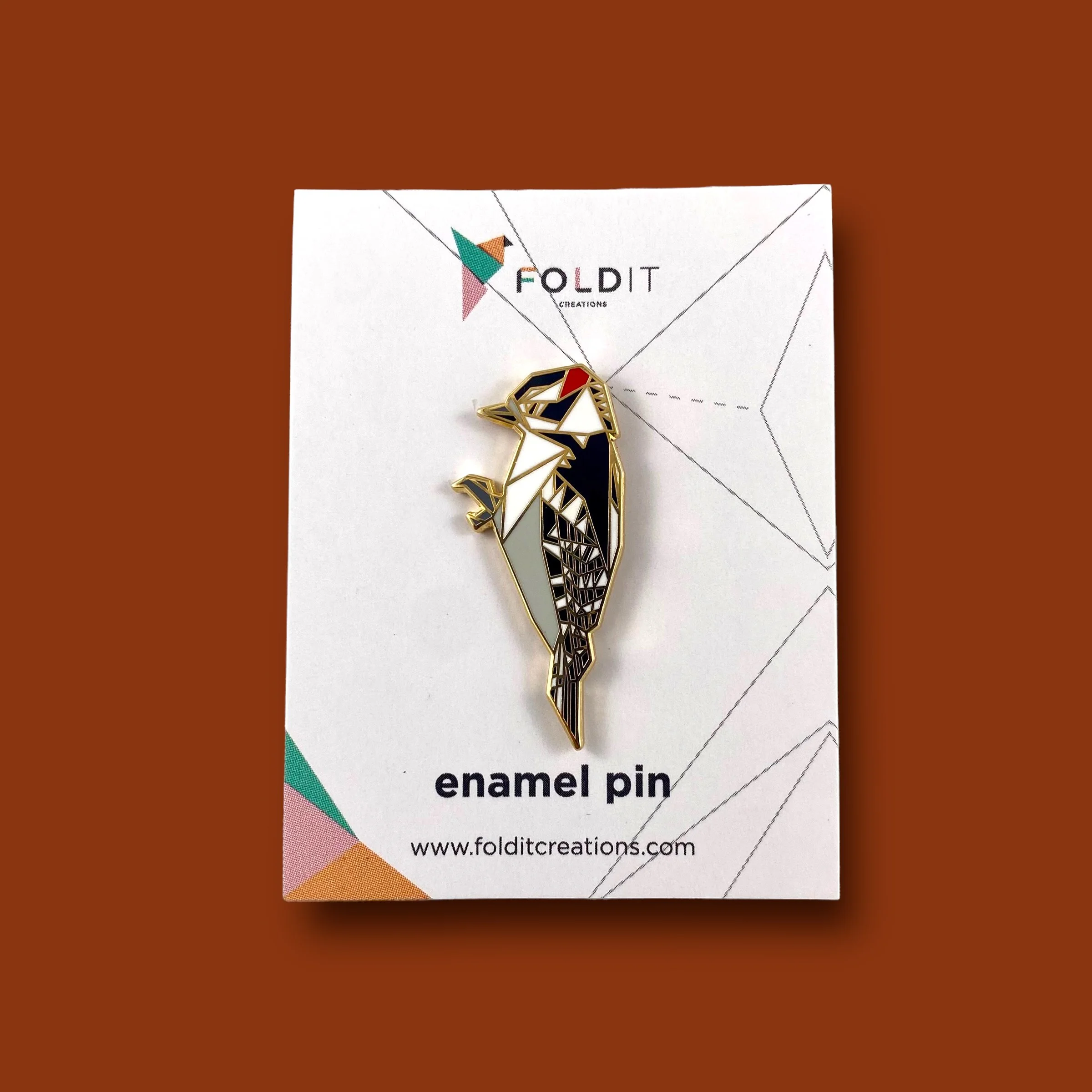 Origami downy woodpecker enamel pin – a unique bird themed gift for bird lovers and bird watchers. Hard enamel pin with secure double pin backing and original FoldIT Creations design