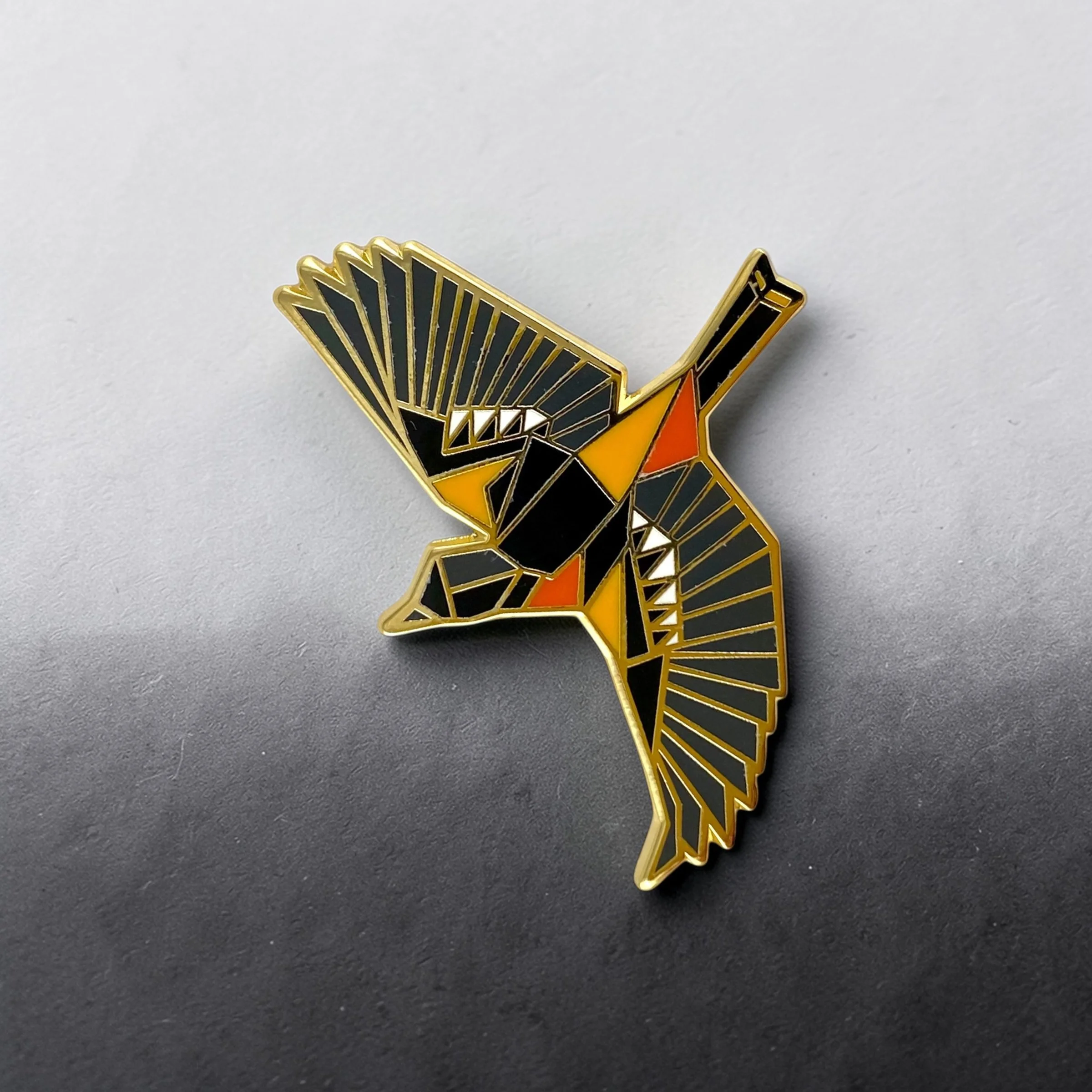 Baltimore Oriole enamel pin – a unique bird themed gift for bird lovers and backyard bird watchers. Hard enamel pin with secure double pin backing and original FoldIT Creations design.