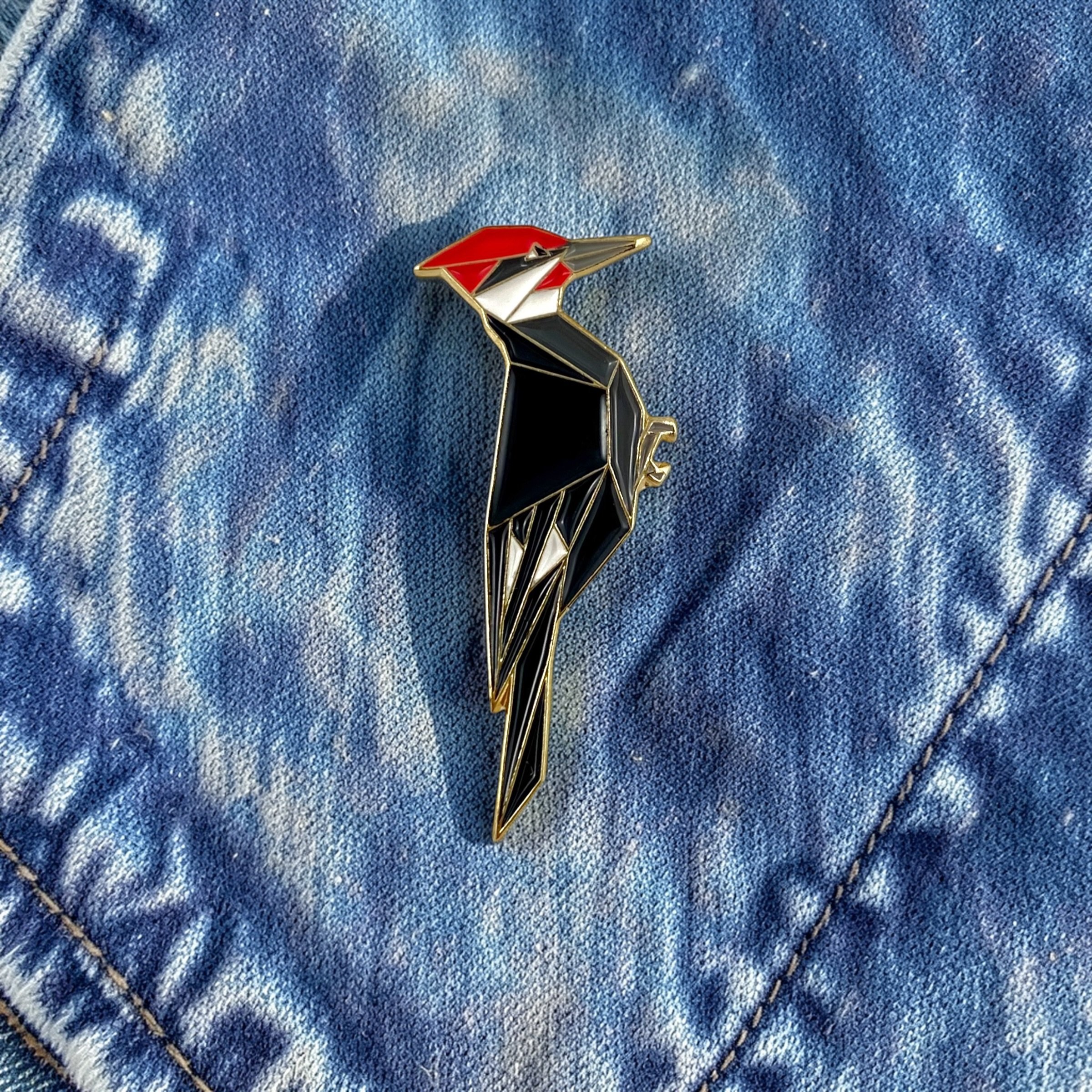 Origami pileated woodpecker enamel pin – a unique bird themed gift for bird lovers and bird watchers. Soft enamel pin with secure double pin backing and original FoldIT Creations design.