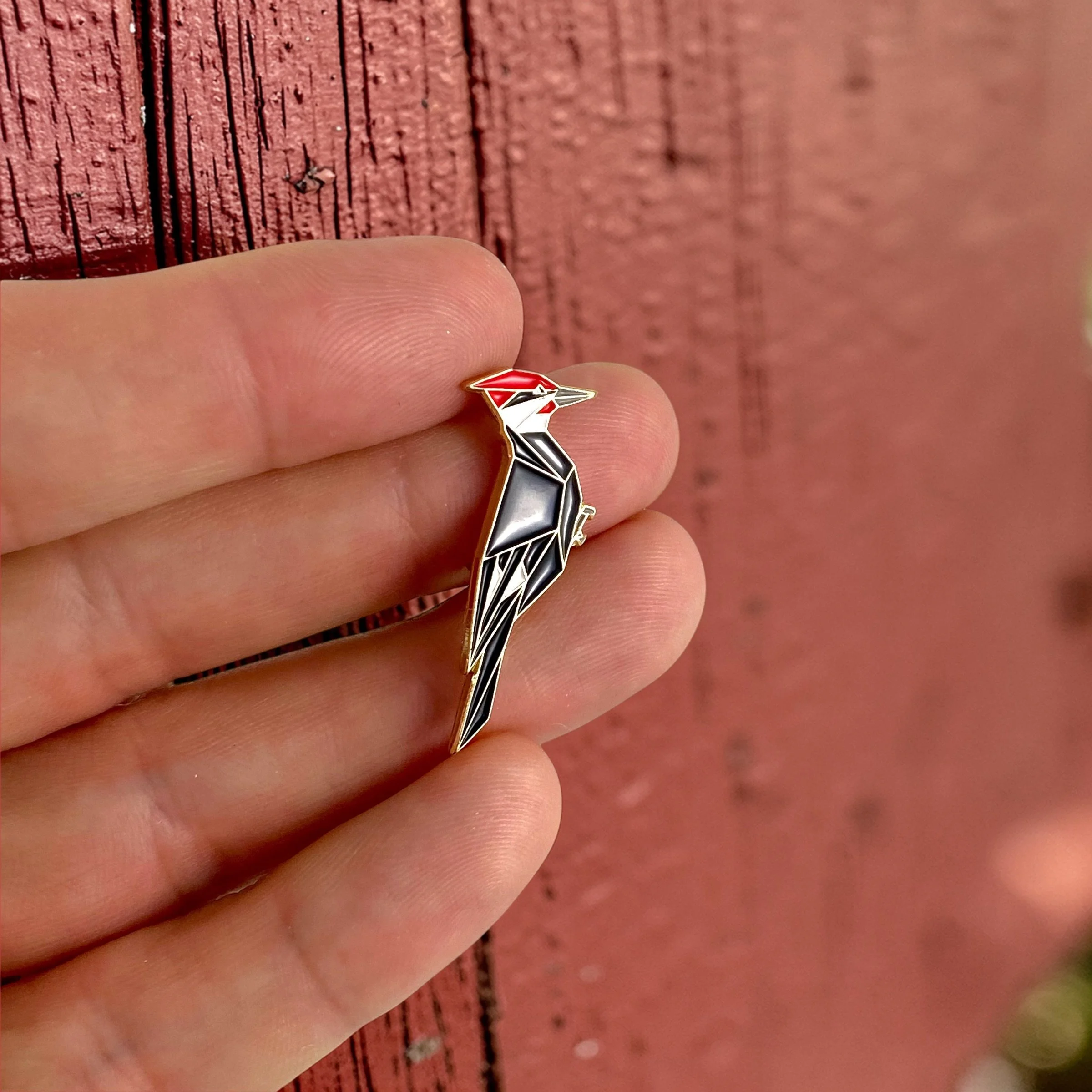 Origami pileated woodpecker enamel pin – a unique bird themed gift for bird lovers and bird watchers. Soft enamel pin with secure double pin backing and original FoldIT Creations design.