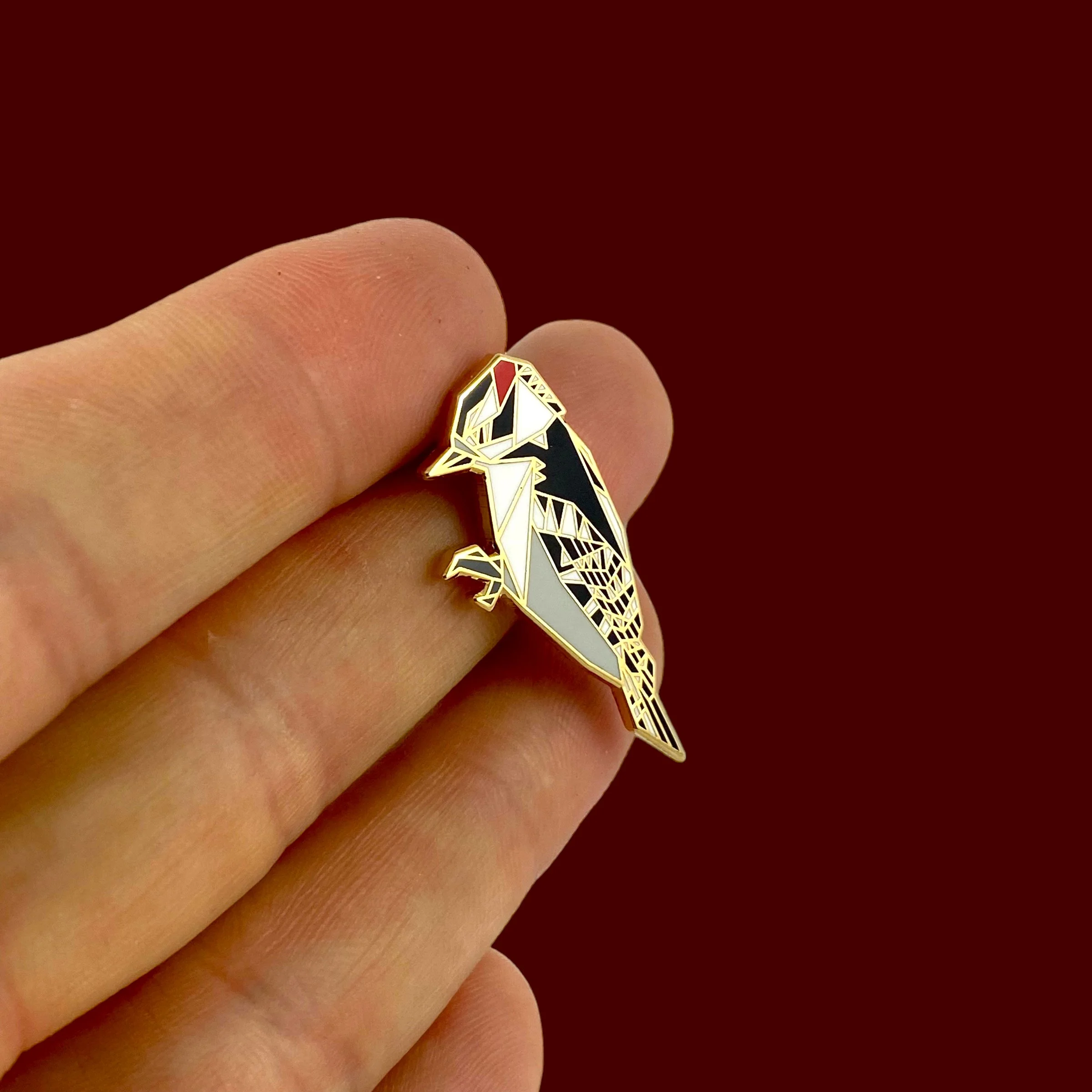 Origami downy woodpecker enamel pin – a unique bird themed gift for bird lovers and bird watchers. Hard enamel pin with secure double pin backing and original FoldIT Creations design