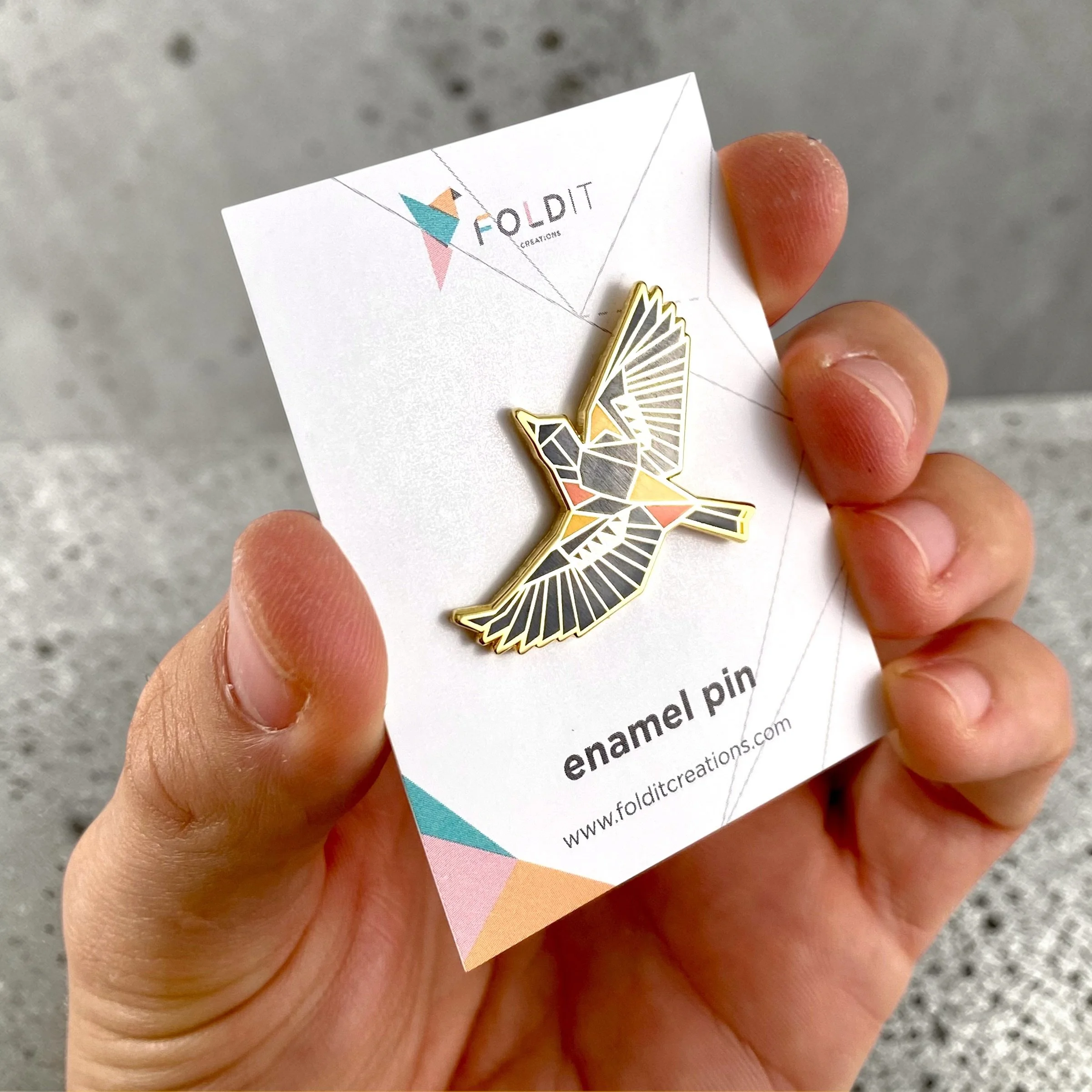 Baltimore Oriole enamel pin – a unique bird themed gift for bird lovers and backyard bird watchers. Hard enamel pin with secure double pin backing and original FoldIT Creations design.