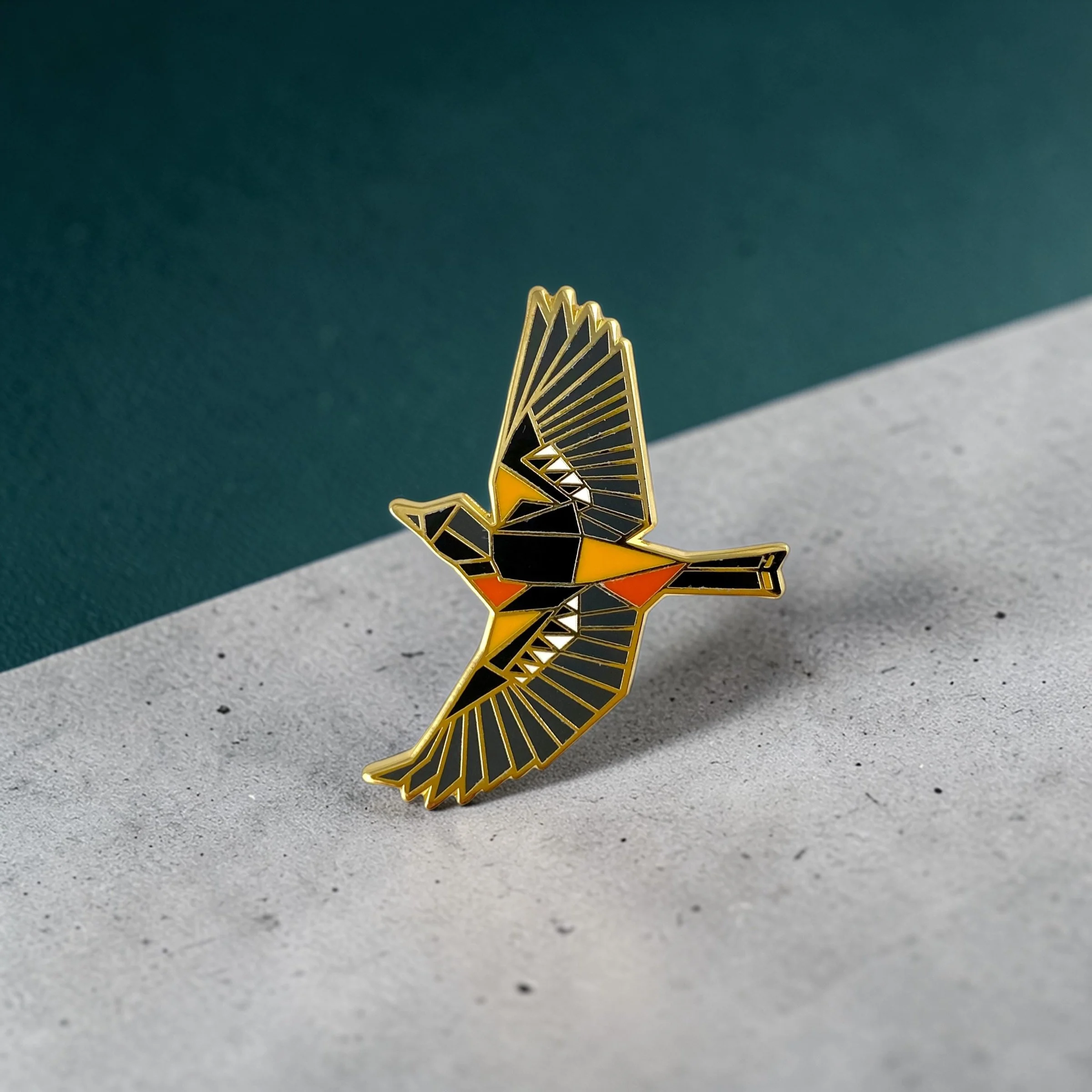 Baltimore Oriole enamel pin – a unique bird themed gift for bird lovers and backyard bird watchers. Hard enamel pin with secure double pin backing and original FoldIT Creations design.