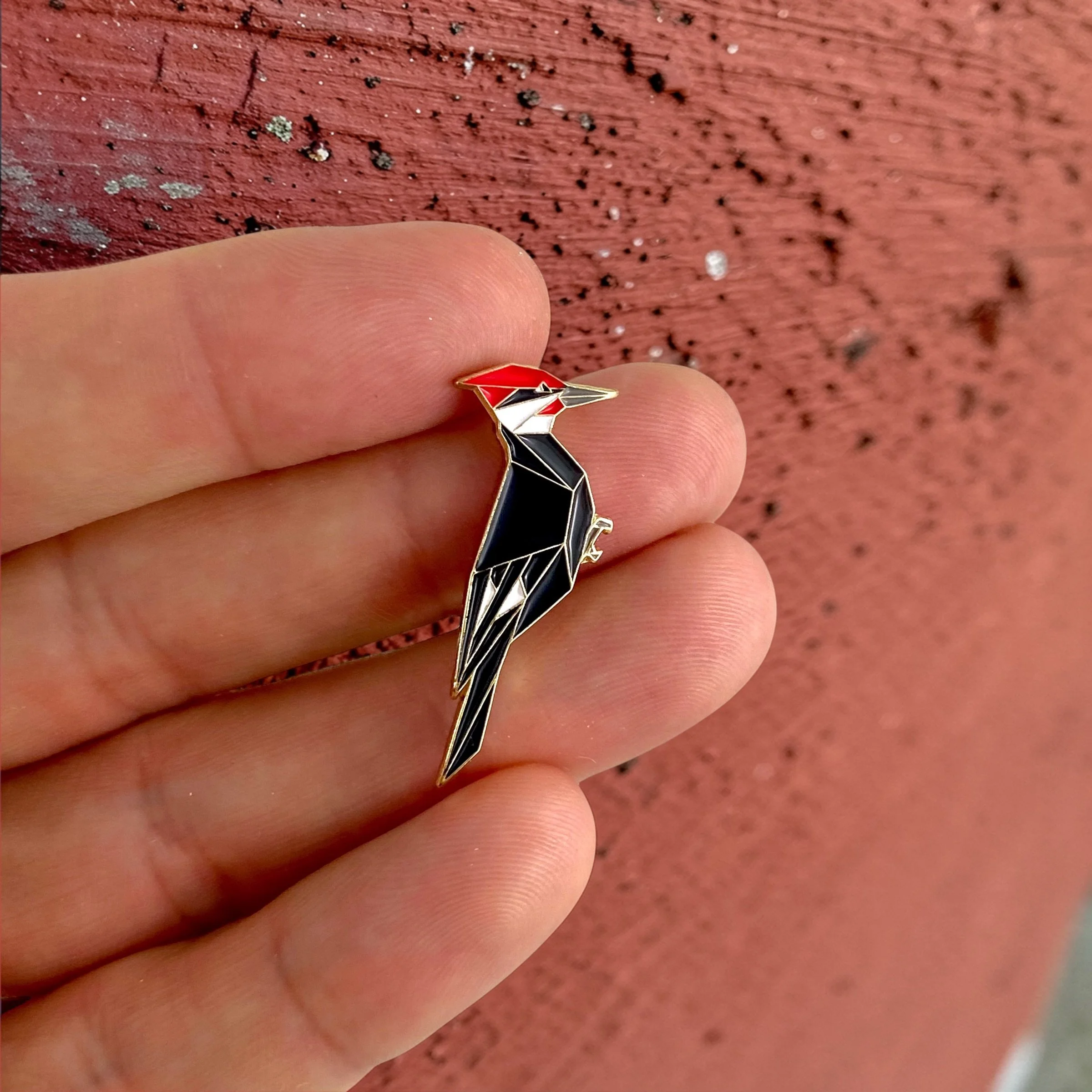 Origami pileated woodpecker enamel pin – a unique bird themed gift for bird lovers and bird watchers. Soft enamel pin with secure double pin backing and original FoldIT Creations design.