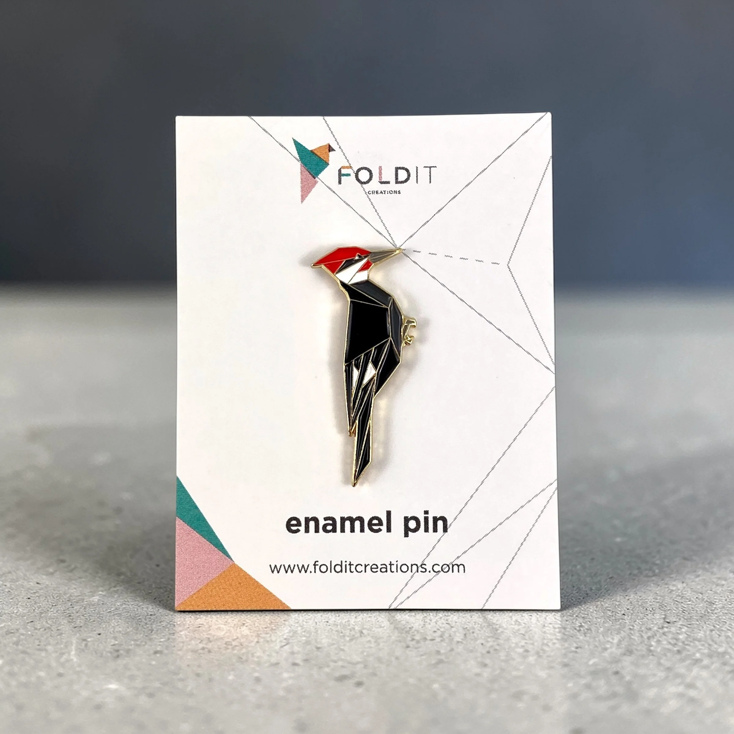 Origami pileated woodpecker enamel pin – a unique bird themed gift for bird lovers and bird watchers. Soft enamel pin with secure double pin backing and original FoldIT Creations design.