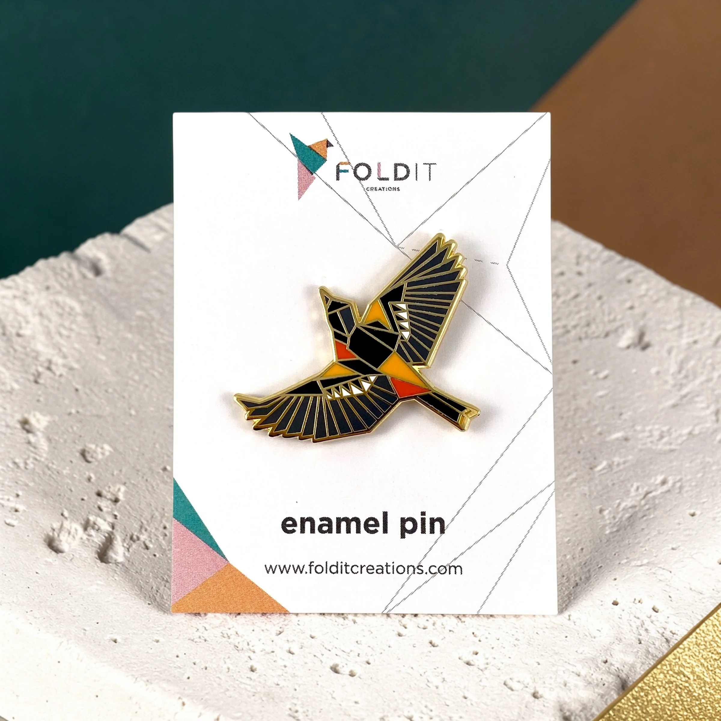 Baltimore Oriole enamel pin – a unique bird themed gift for bird lovers and backyard bird watchers. Hard enamel pin with secure double pin backing and original FoldIT Creations design.