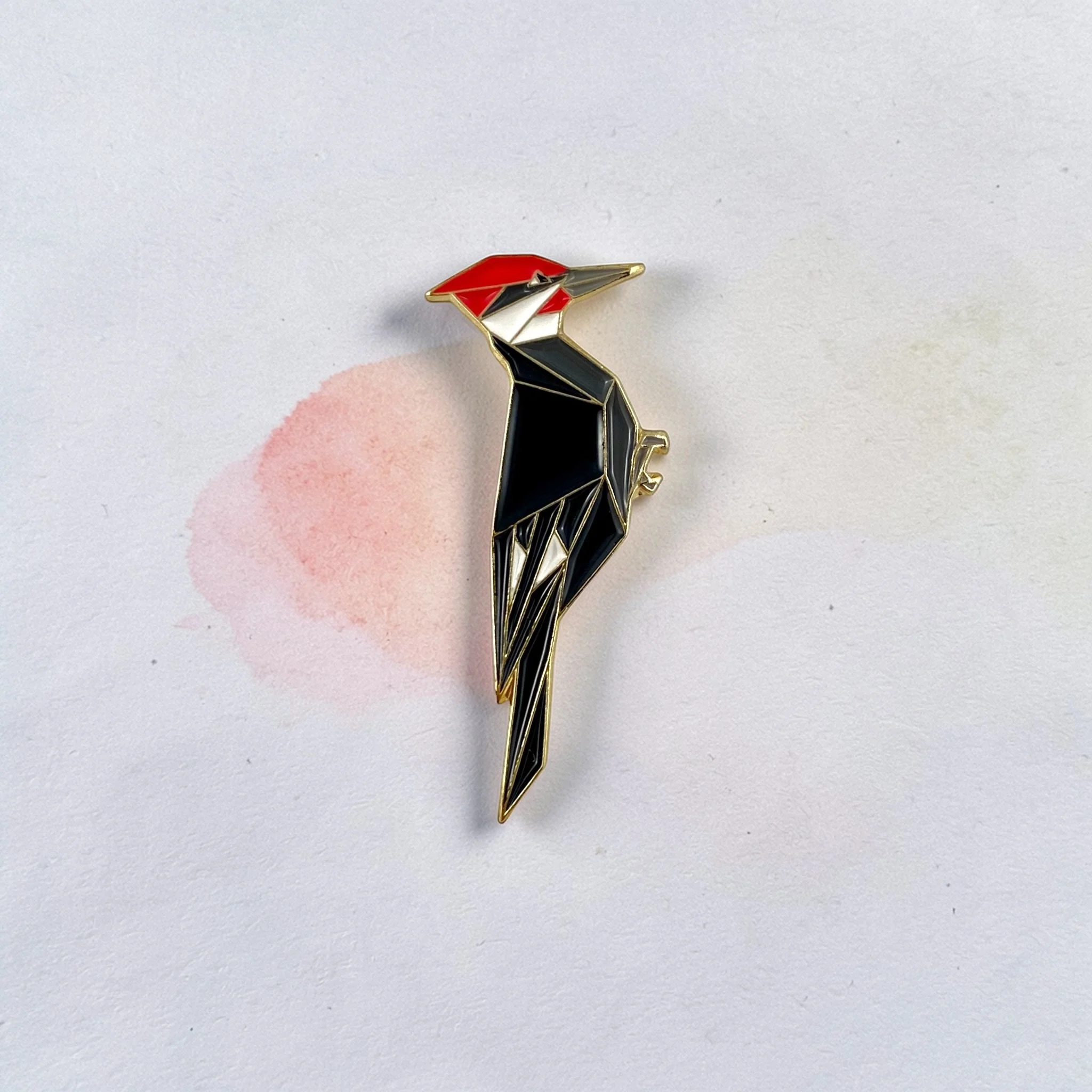 Origami pileated woodpecker enamel pin – a unique bird themed gift for bird lovers and bird watchers. Soft enamel pin with secure double pin backing and original FoldIT Creations design.