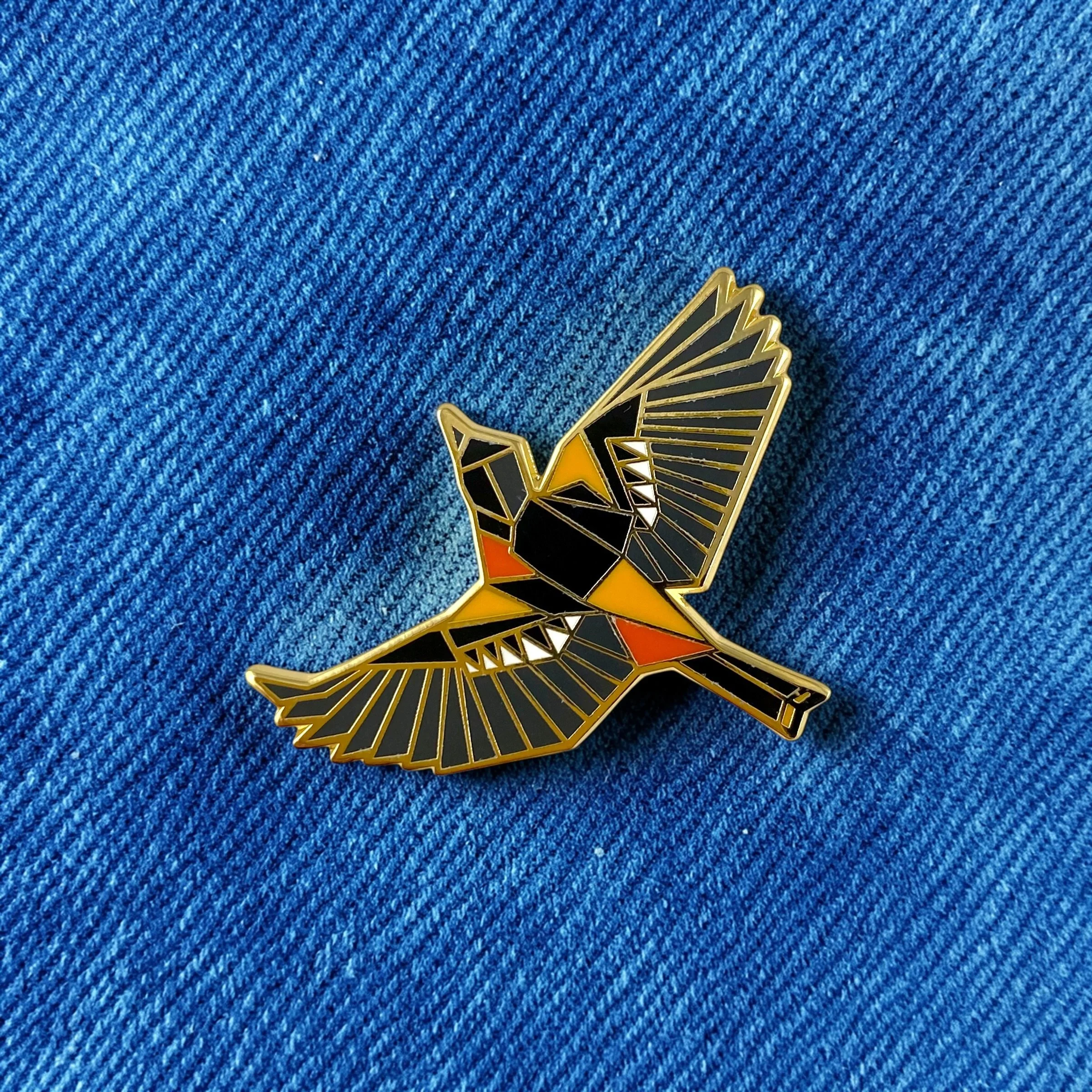 Baltimore Oriole enamel pin – a unique bird themed gift for bird lovers and backyard bird watchers. Hard enamel pin with secure double pin backing and original FoldIT Creations design.