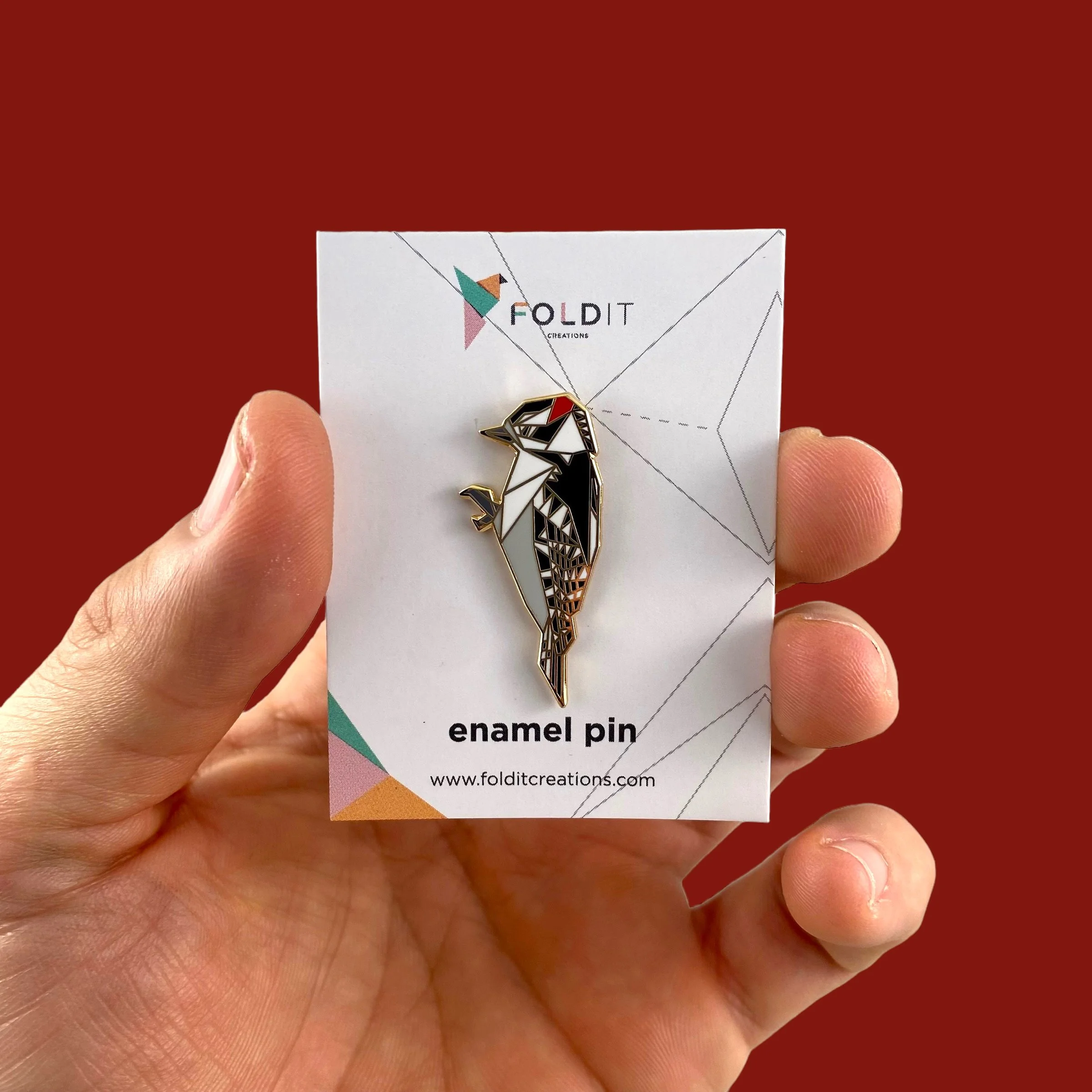 Origami downy woodpecker enamel pin – a unique bird themed gift for bird lovers and bird watchers. Hard enamel pin with secure double pin backing and original FoldIT Creations design