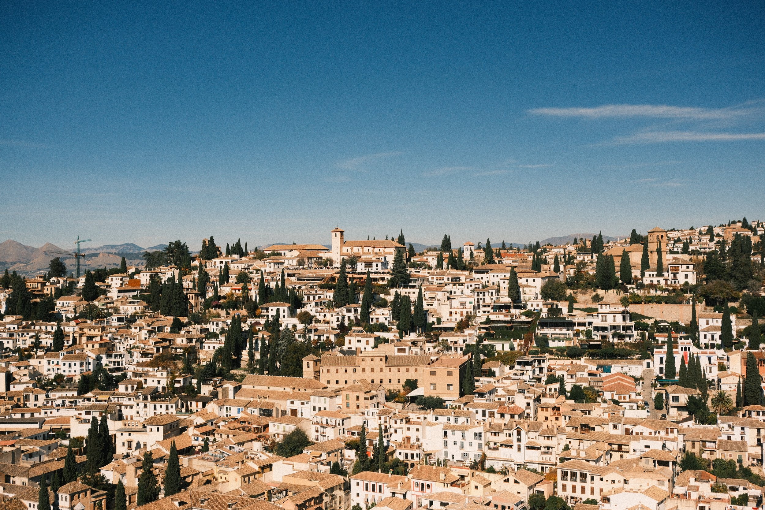 Whitewashed houses of the Albaicín spilling down the hillside, Granada, Andalucía, Spain, by Zyan Sachs