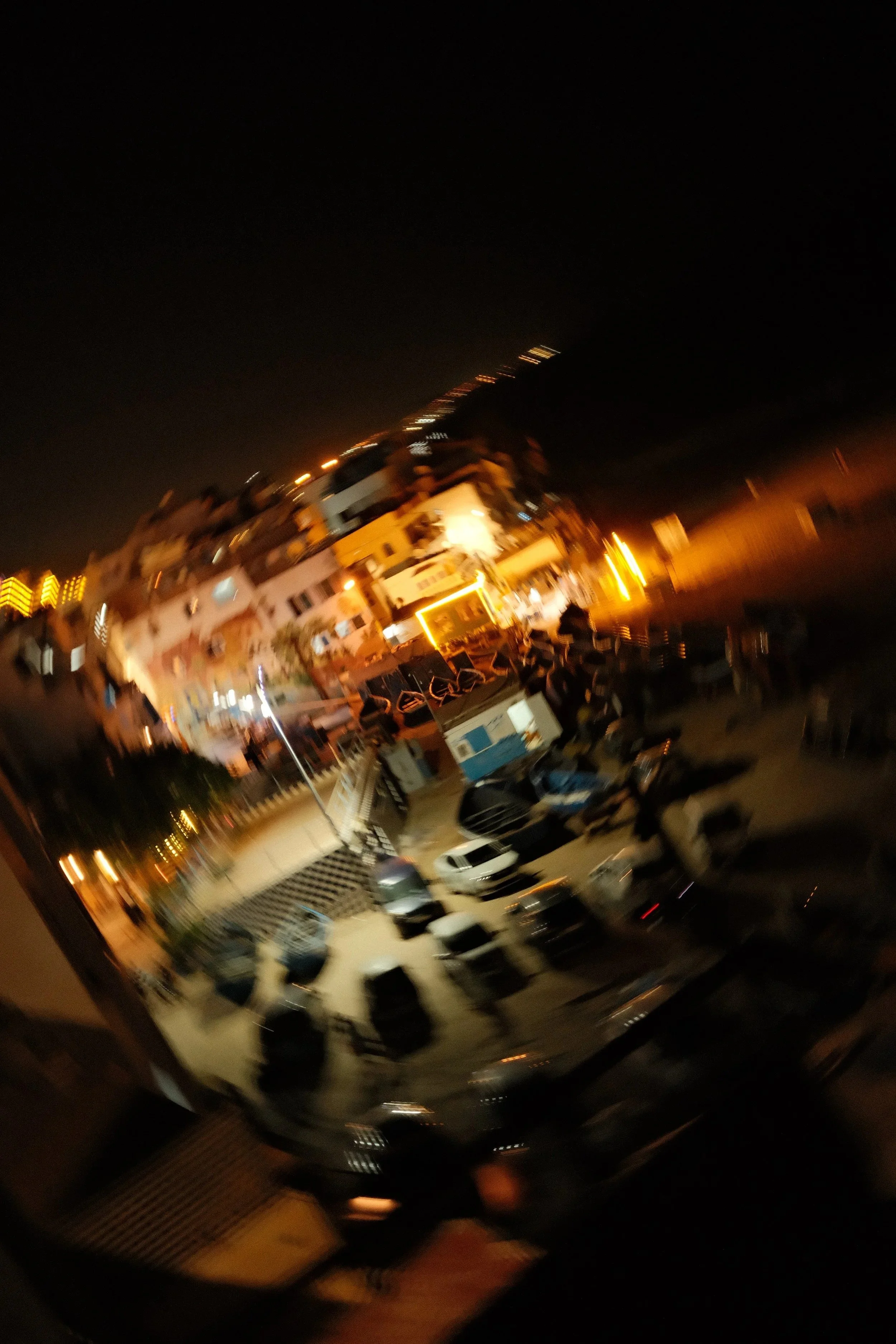 Café terrace glowing at night seen from above, Taghazout, Morocco - fine art print by Zyan Sachs