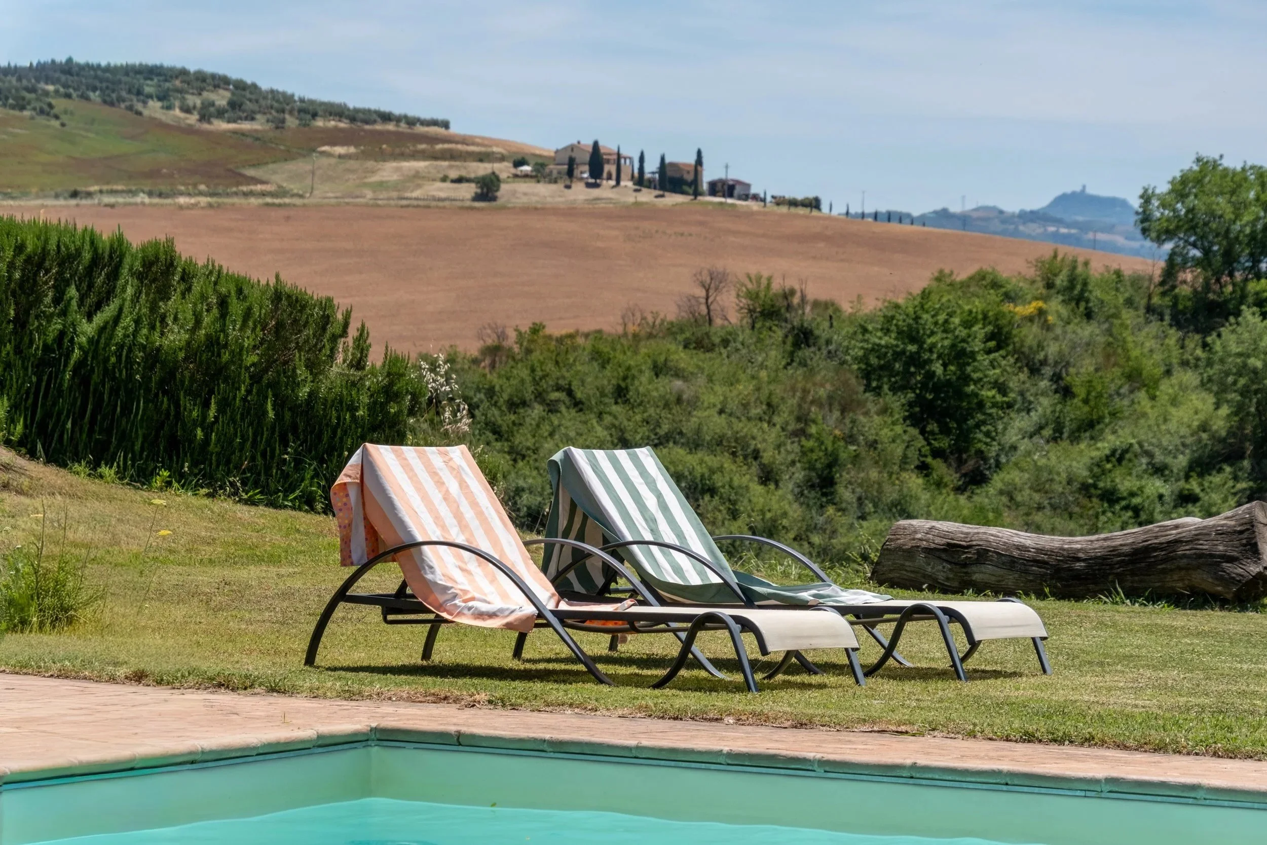 Striped sun loungers on the lawn beside the pool at Agriturismo Selvoli, Val d'Orcia, Tuscany, by Zyan Sachs